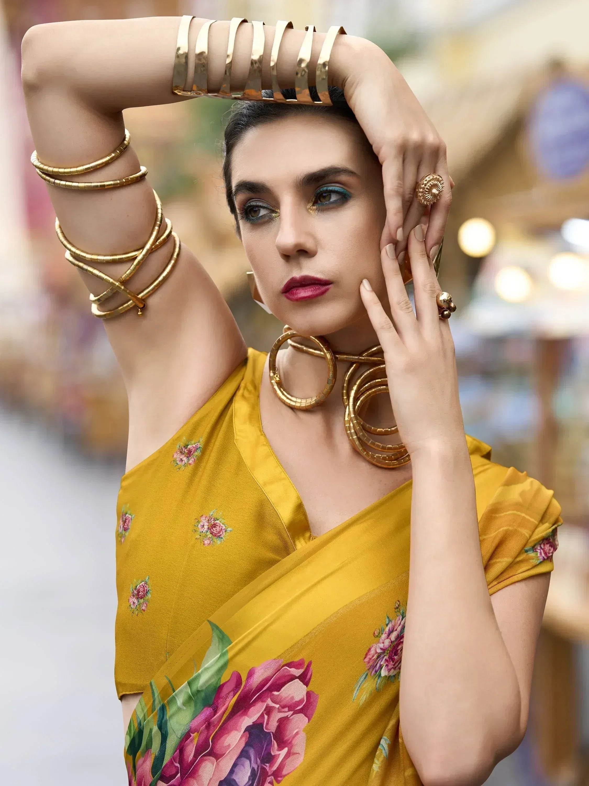 Woman in mustard floral saree with gold jewelry, ethnic Indian wear