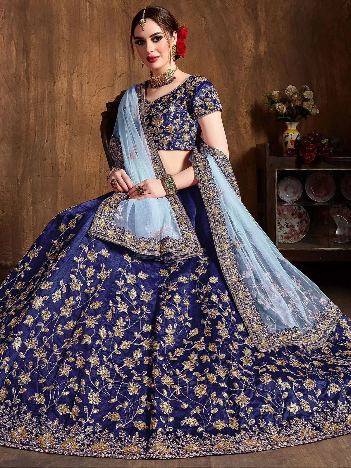 Royal blue embroidered lehenga choli with gold floral work and light blue dupatta, perfect for Indian weddings and festive occasions.