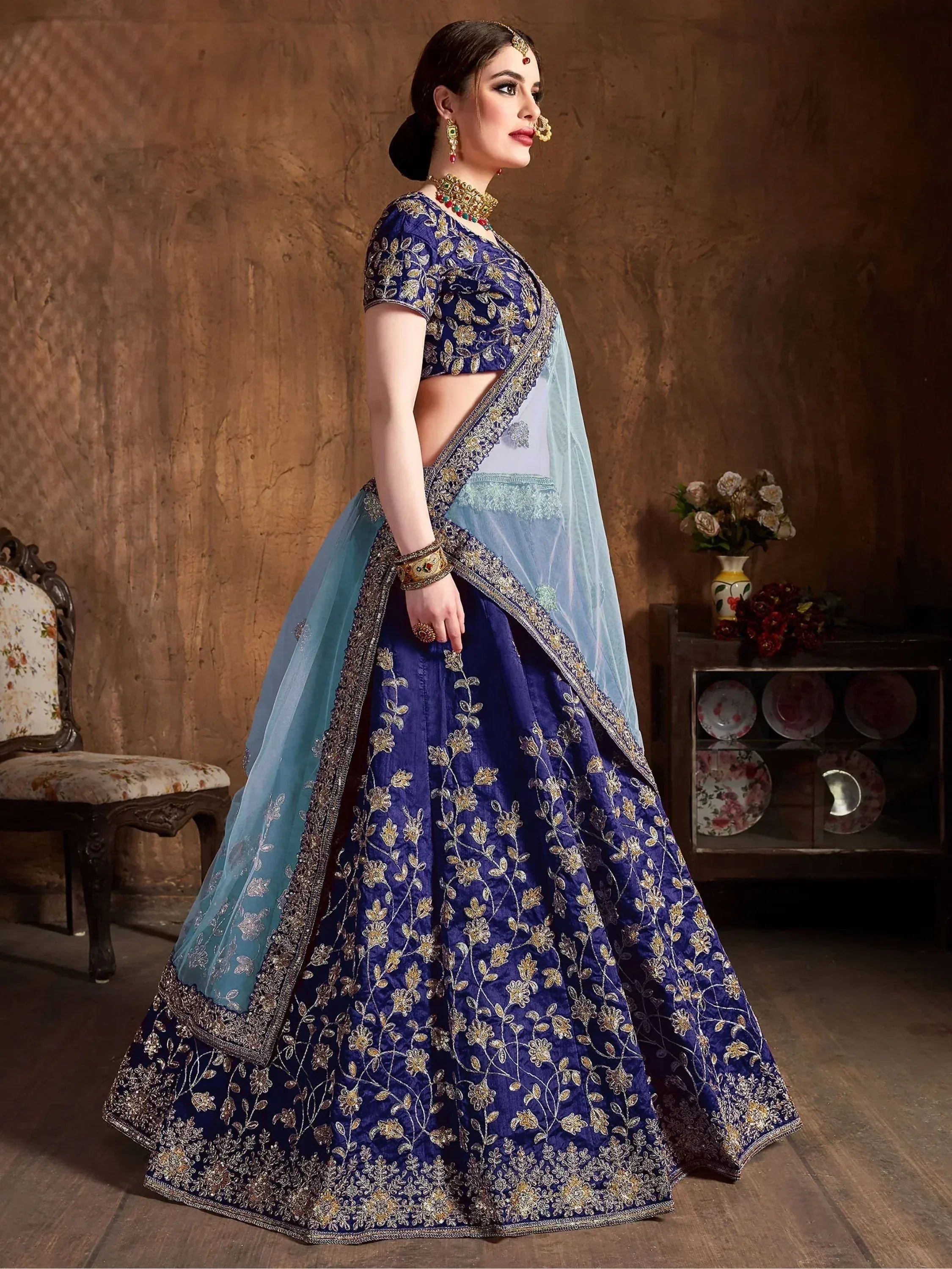 Royal blue embroidered lehenga choli with gold floral work and light blue dupatta, perfect for Indian weddings and festive occasions.