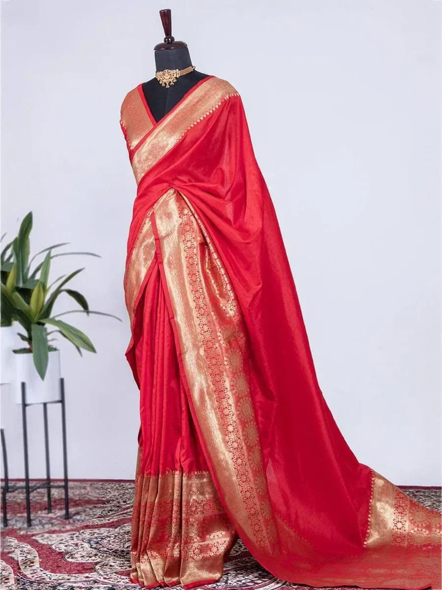 Red and gold designer saree with intricate border, displayed on mannequin for ethnic wear