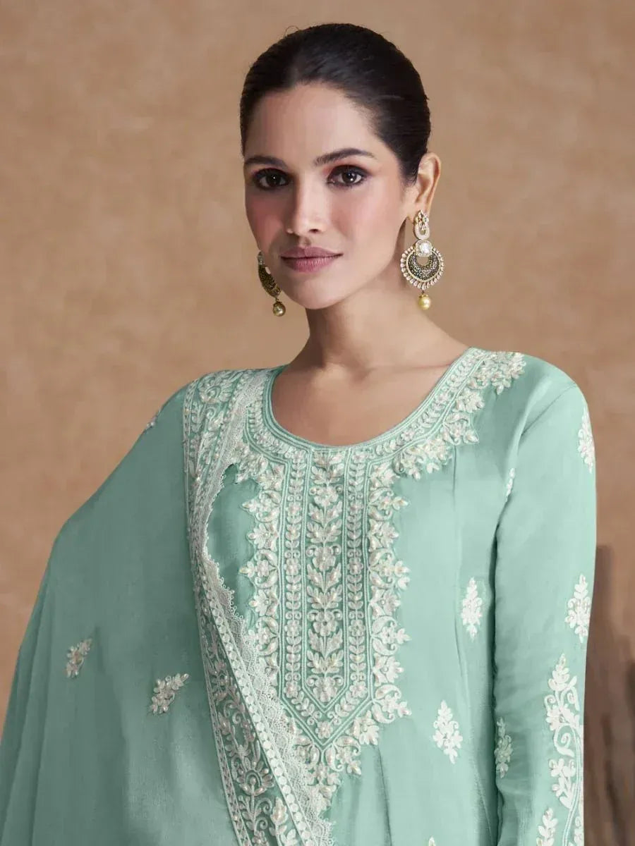 Mint green embroidered ethnic kurta with white floral detailing and matching dupatta, styled with jhumka earrings.