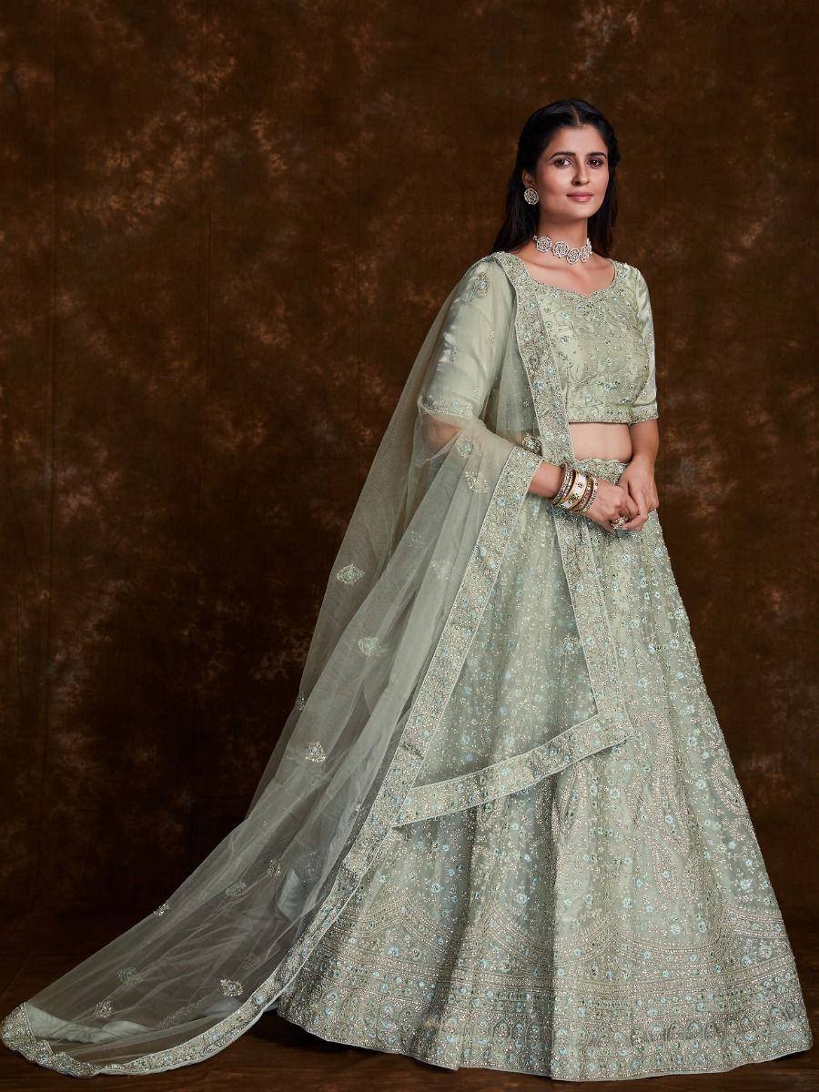 Mint green designer lehenga choli with intricate embroidery and sheer dupatta, perfect for weddings and festive occasions.