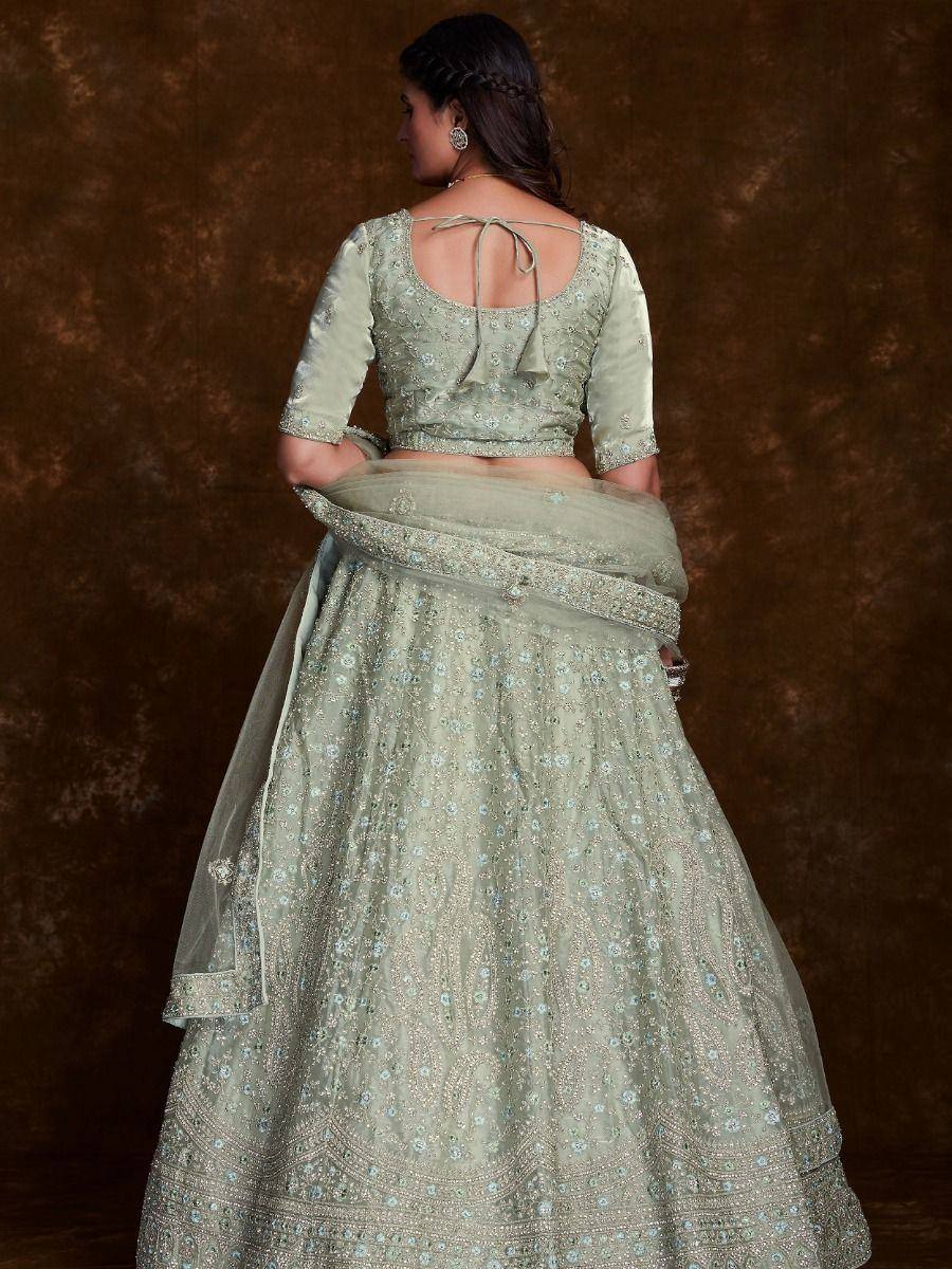 Elegant sage green lehenga choli with floral embroidery and tie-back blouse, perfect for Indian weddings and festive occasions.