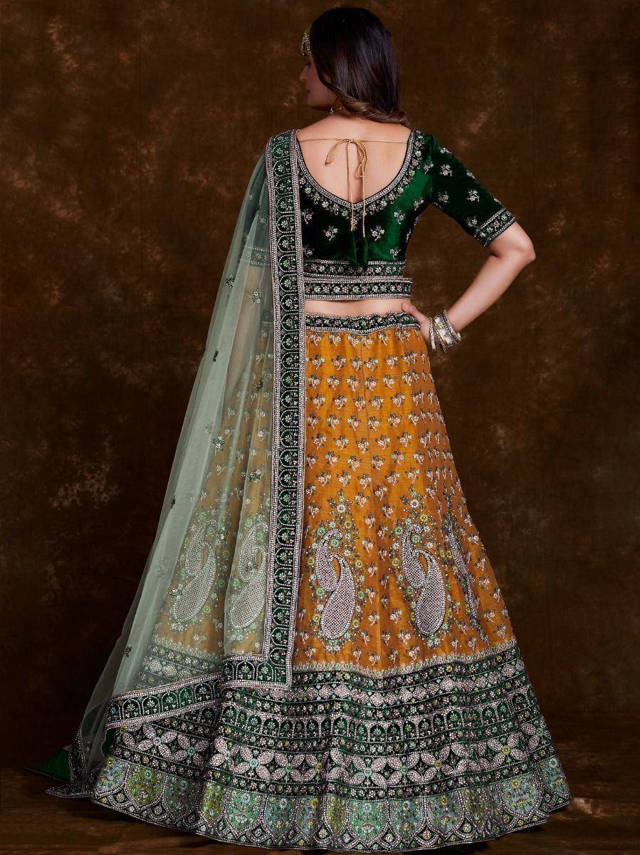 Green velvet blouse with mustard lehenga, floral embroidery, and sheer dupatta for Indian ethnic wear
