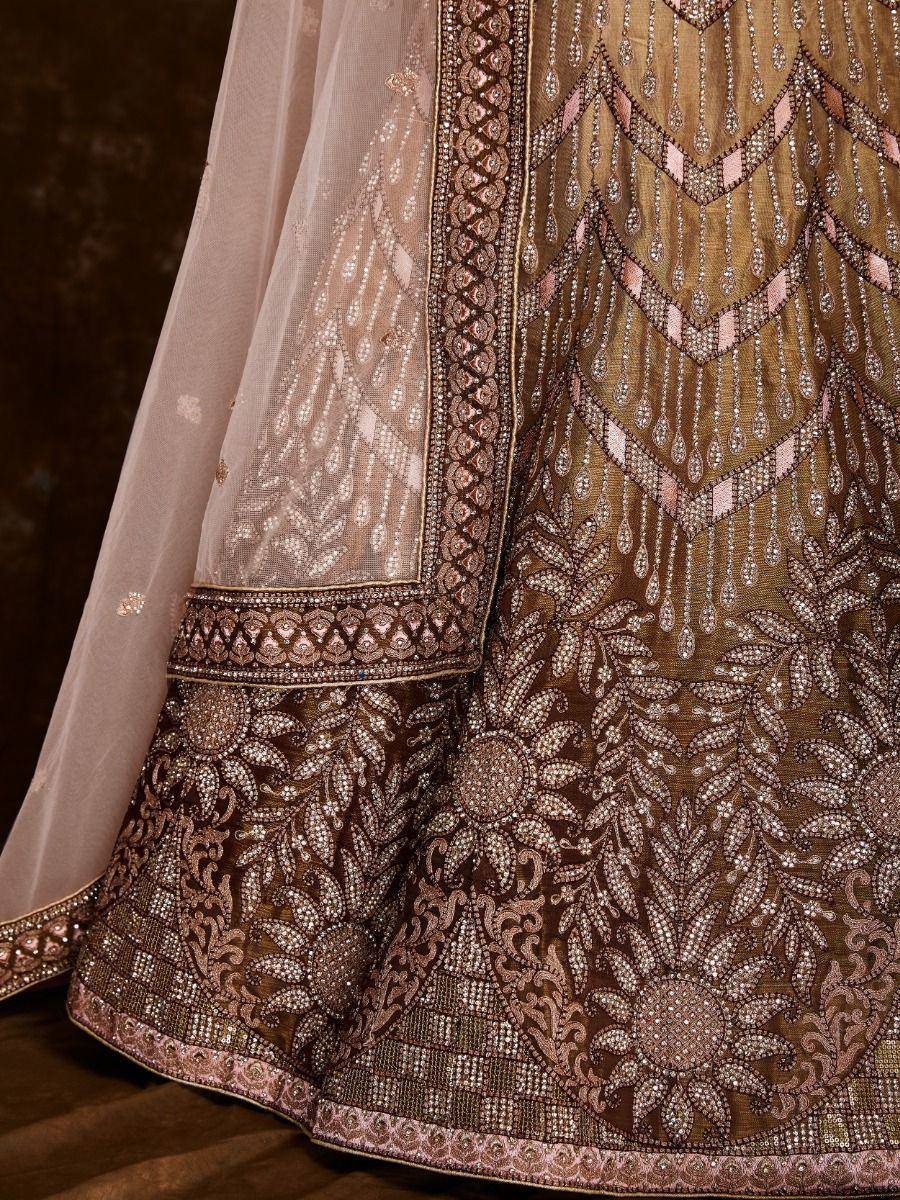 Luxury Indian lehenga with intricate gold and pink embroidery, perfect for weddings and festive occasions.