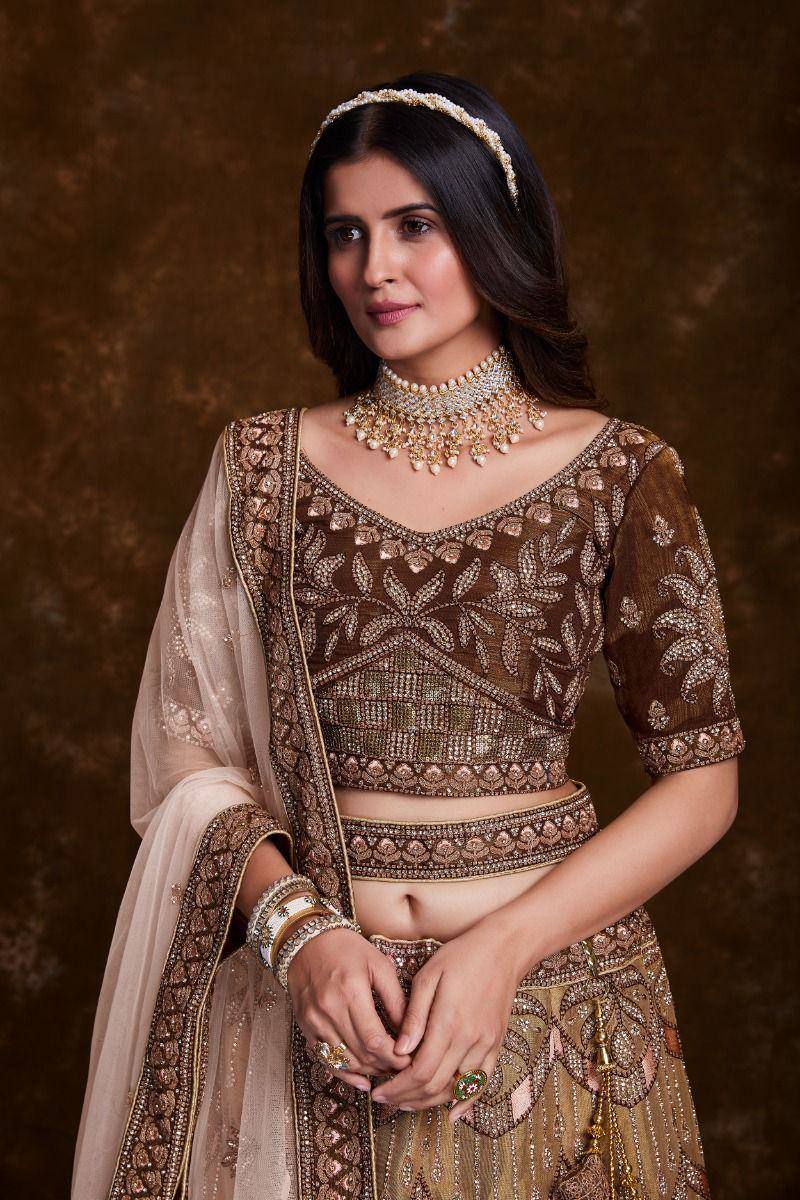 Elegant brown embroidered lehenga choli with gold detailing, perfect for Indian weddings and festive occasions.