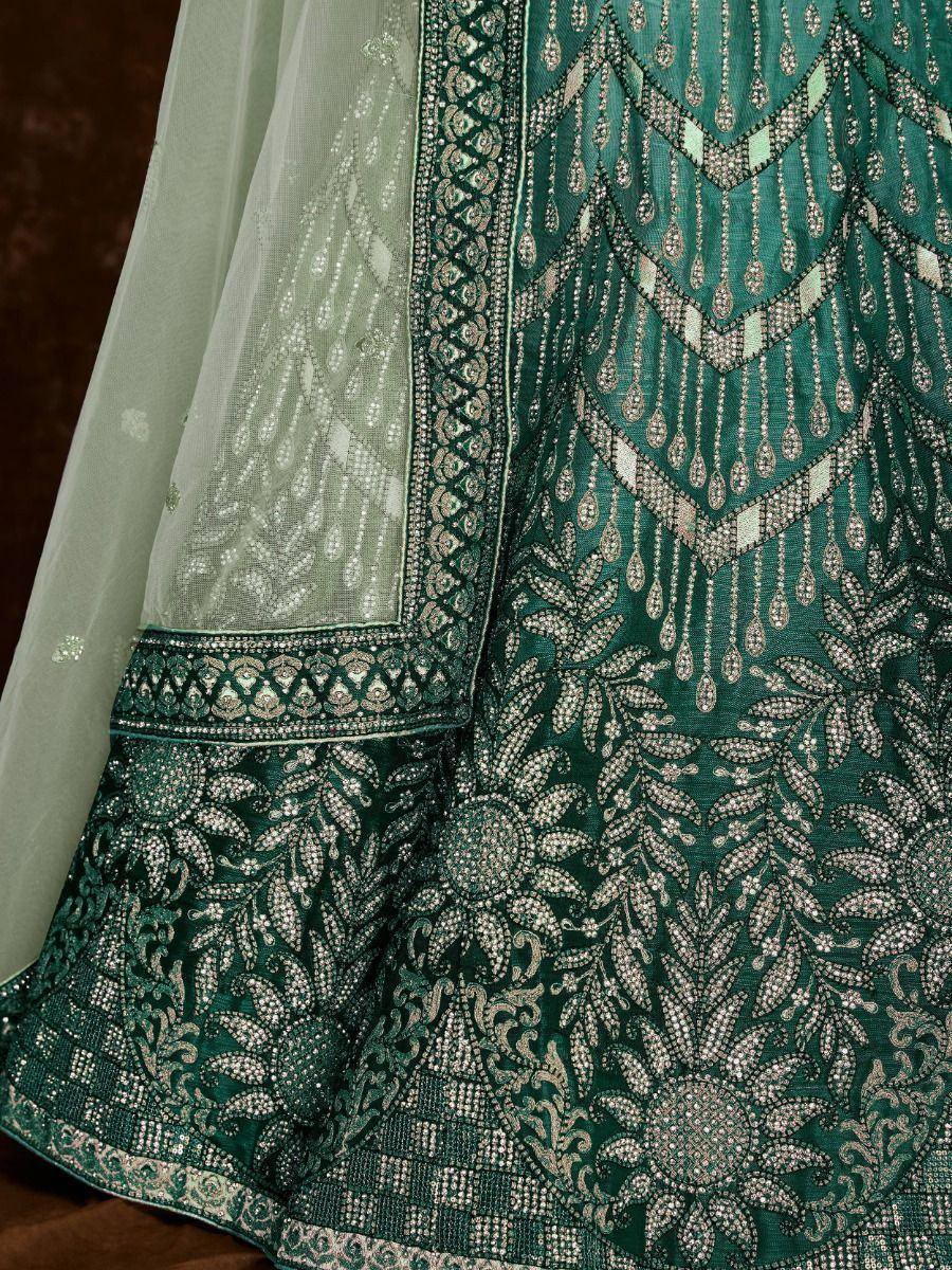 Emerald green designer lehenga with intricate silver embroidery and sheer dupatta, perfect for weddings