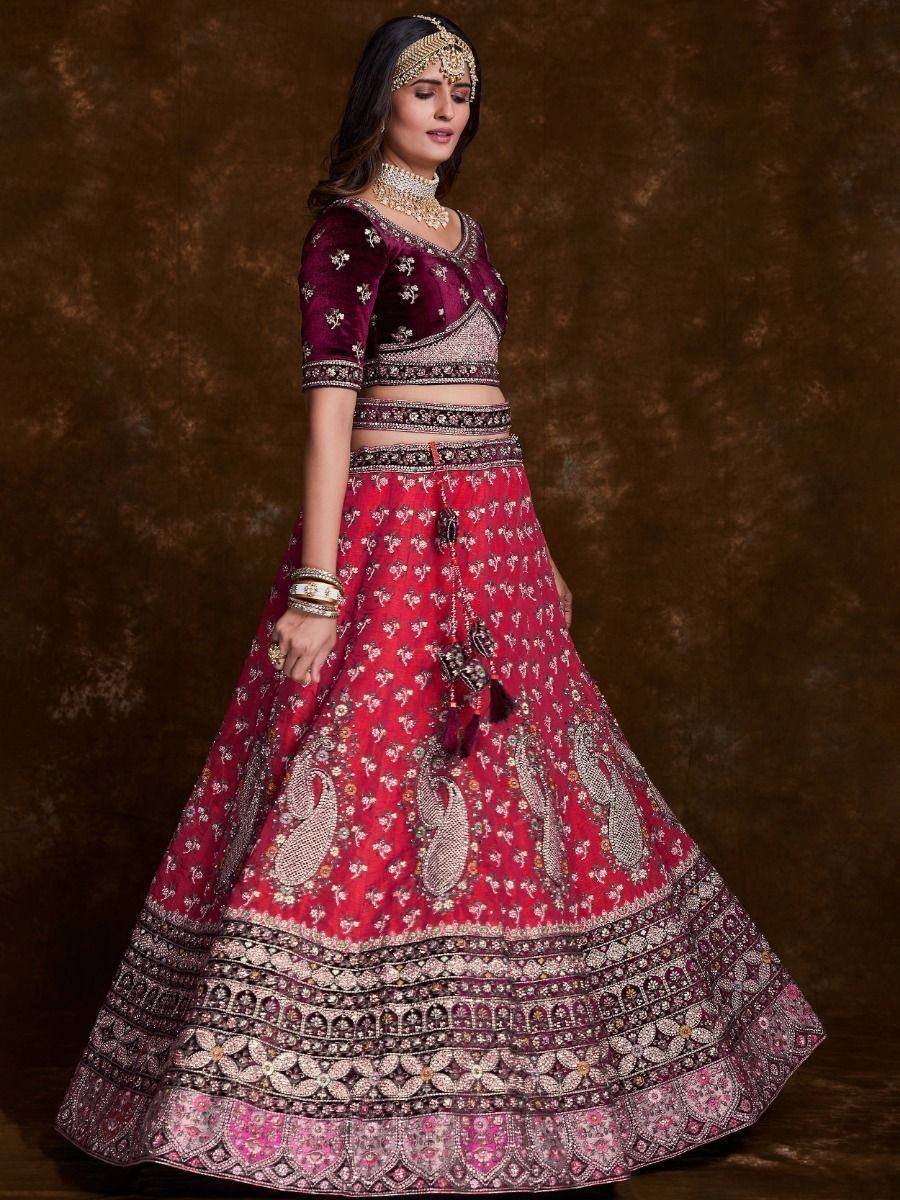 Maroon velvet lehenga choli with intricate embroidery and gold jewelry, perfect for Indian weddings and festive occasions.