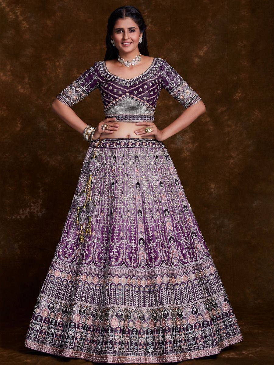 Purple embroidered lehenga choli with intricate floral patterns and silver embellishments, perfect for Indian ethnic wear.