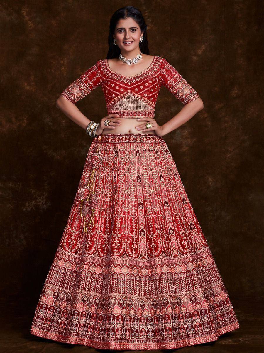 Red embroidered lehenga choli with intricate gold detailing, perfect for Indian weddings and festive occasions.