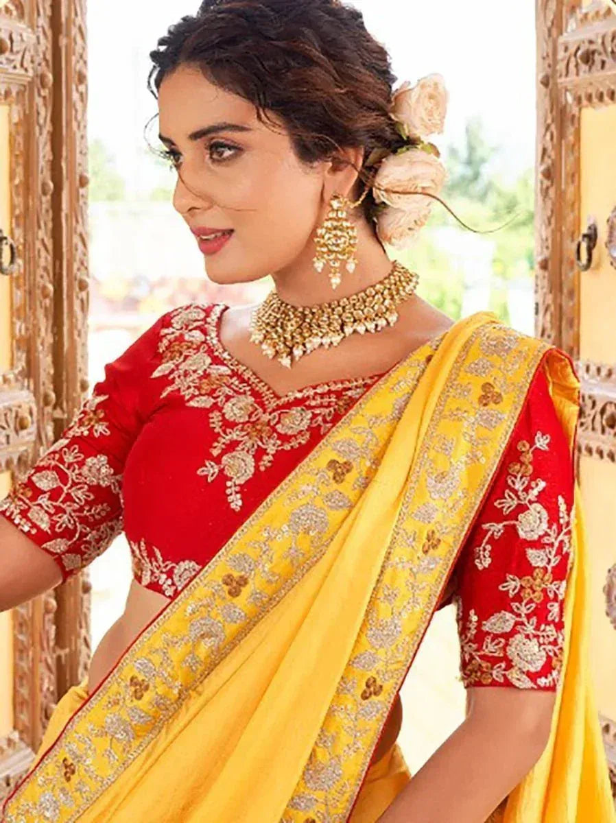 Red and yellow embroidered saree with gold jewelry, perfect for Indian ethnic wear occasions