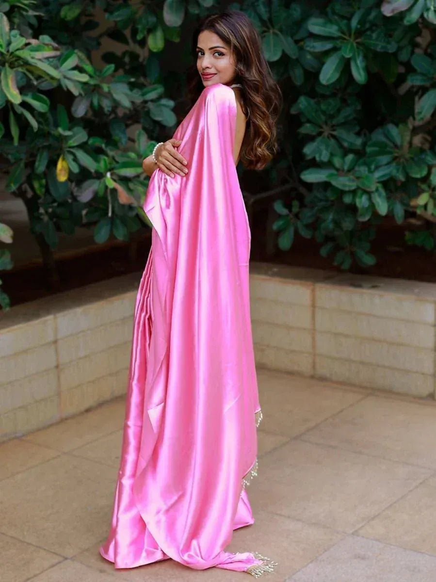 Woman in elegant pink satin ethnic gown with draped back, perfect for Indian occasions