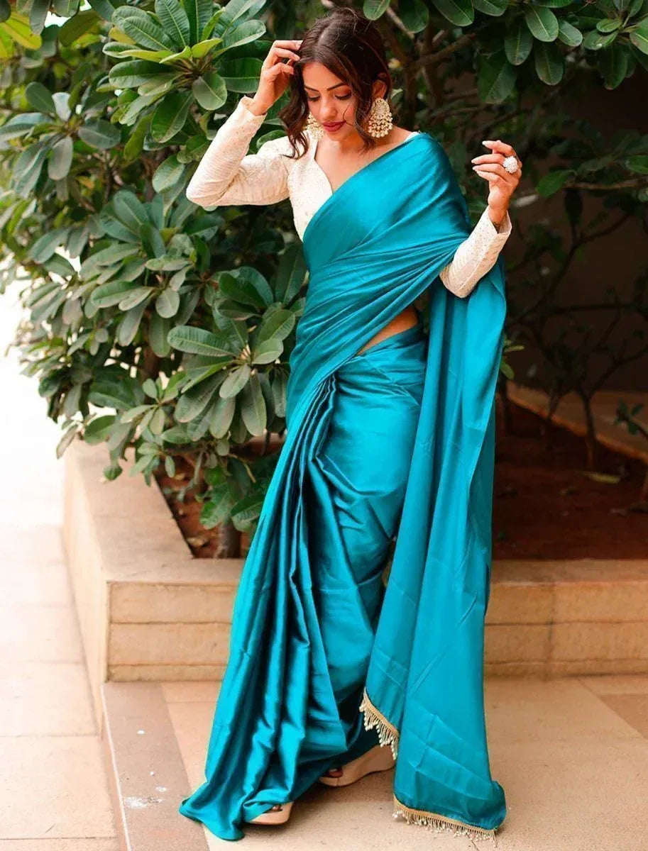 Teal satin saree with gold trim, paired with white blouse, styled for Indian ethnic wear occasions