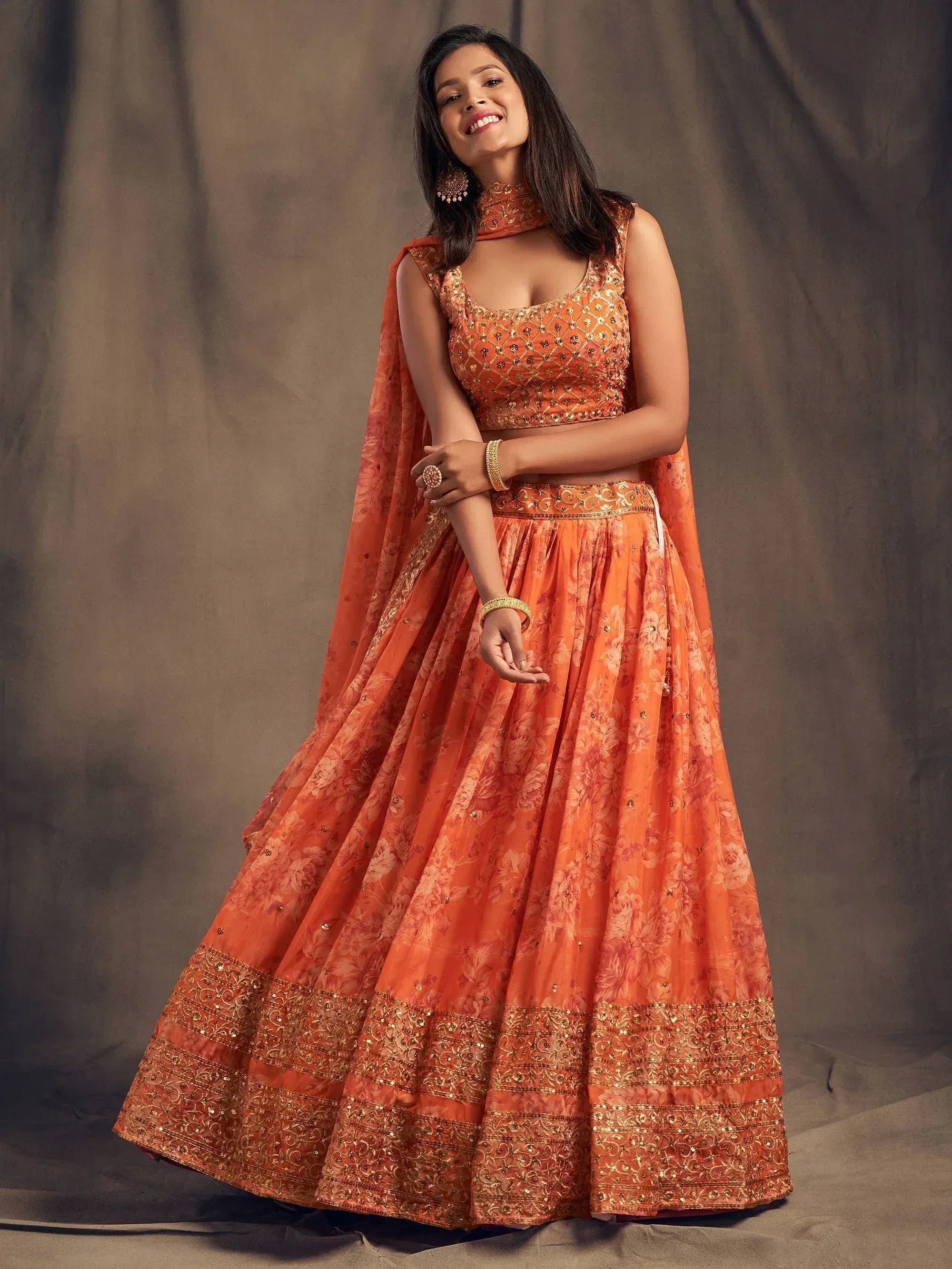 Orange floral lehenga choli with gold embroidery, perfect for Indian weddings and festive occasions.