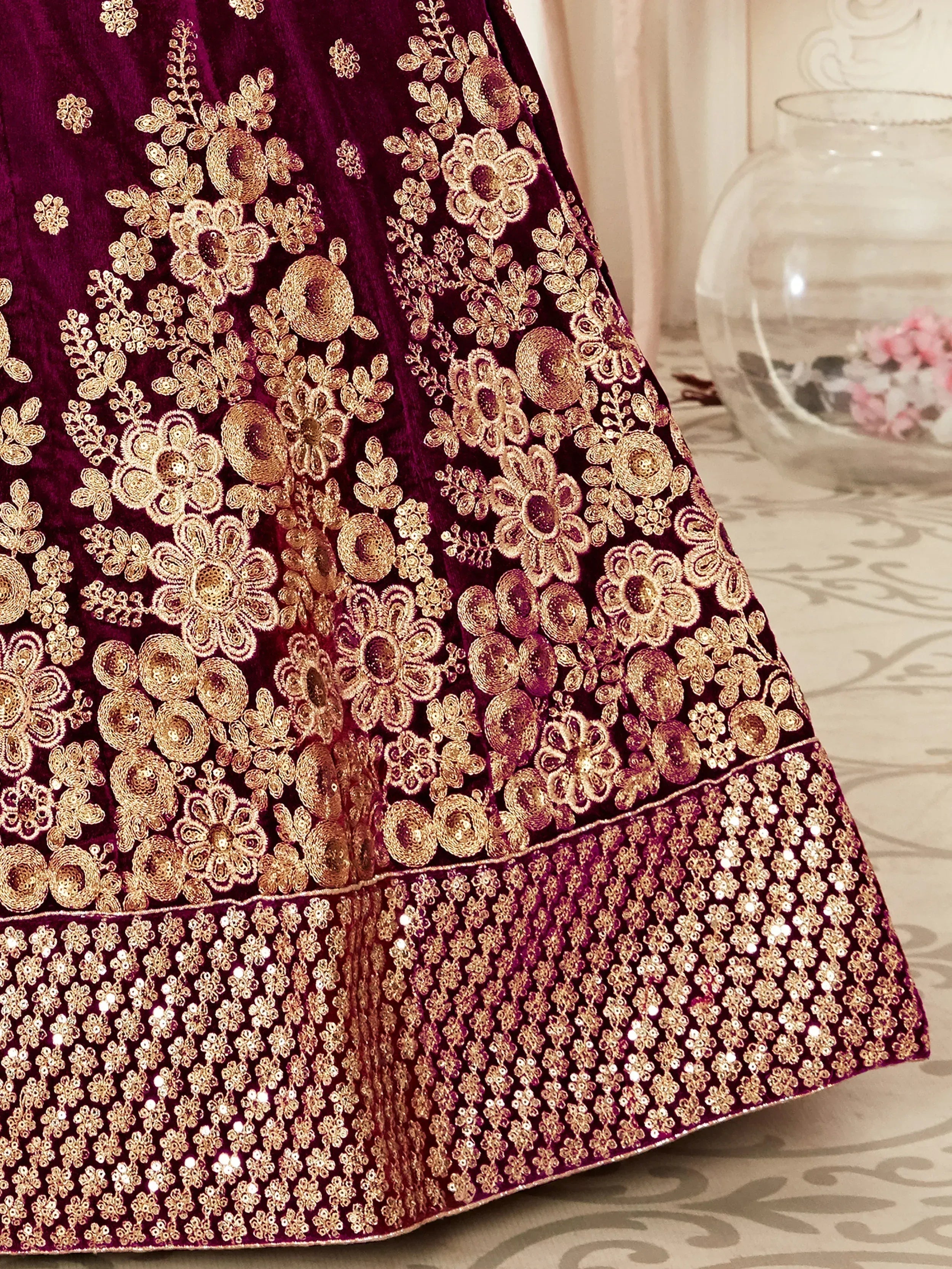 Rich purple velvet lehenga with intricate gold floral embroidery and sequin border, perfect for Indian ethnic wear.