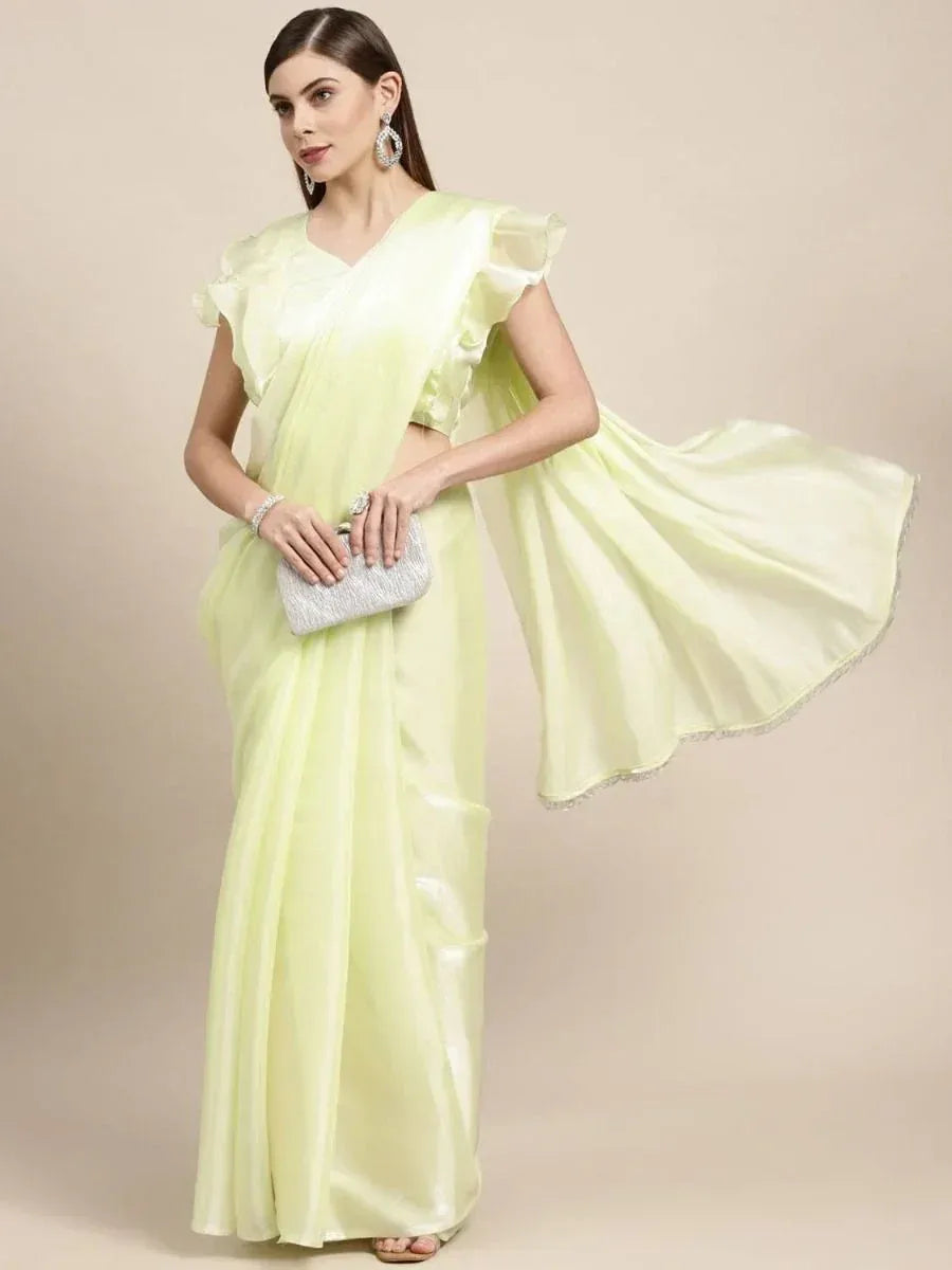 Light green designer saree with ruffled sleeves and sequin border, paired with silver clutch and earrings