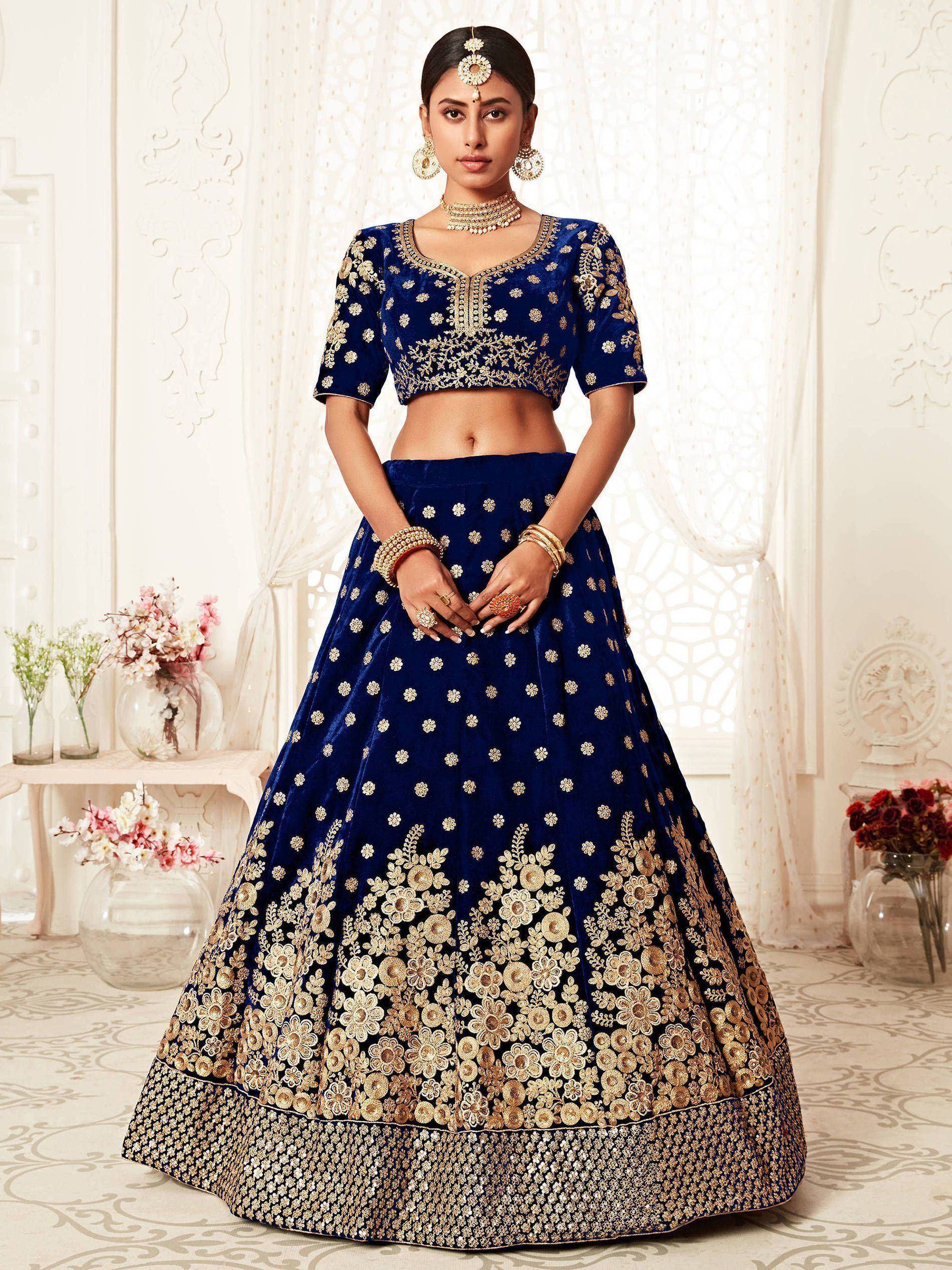 Royal blue velvet lehenga choli with gold floral embroidery, perfect for Indian weddings and festive occasions.