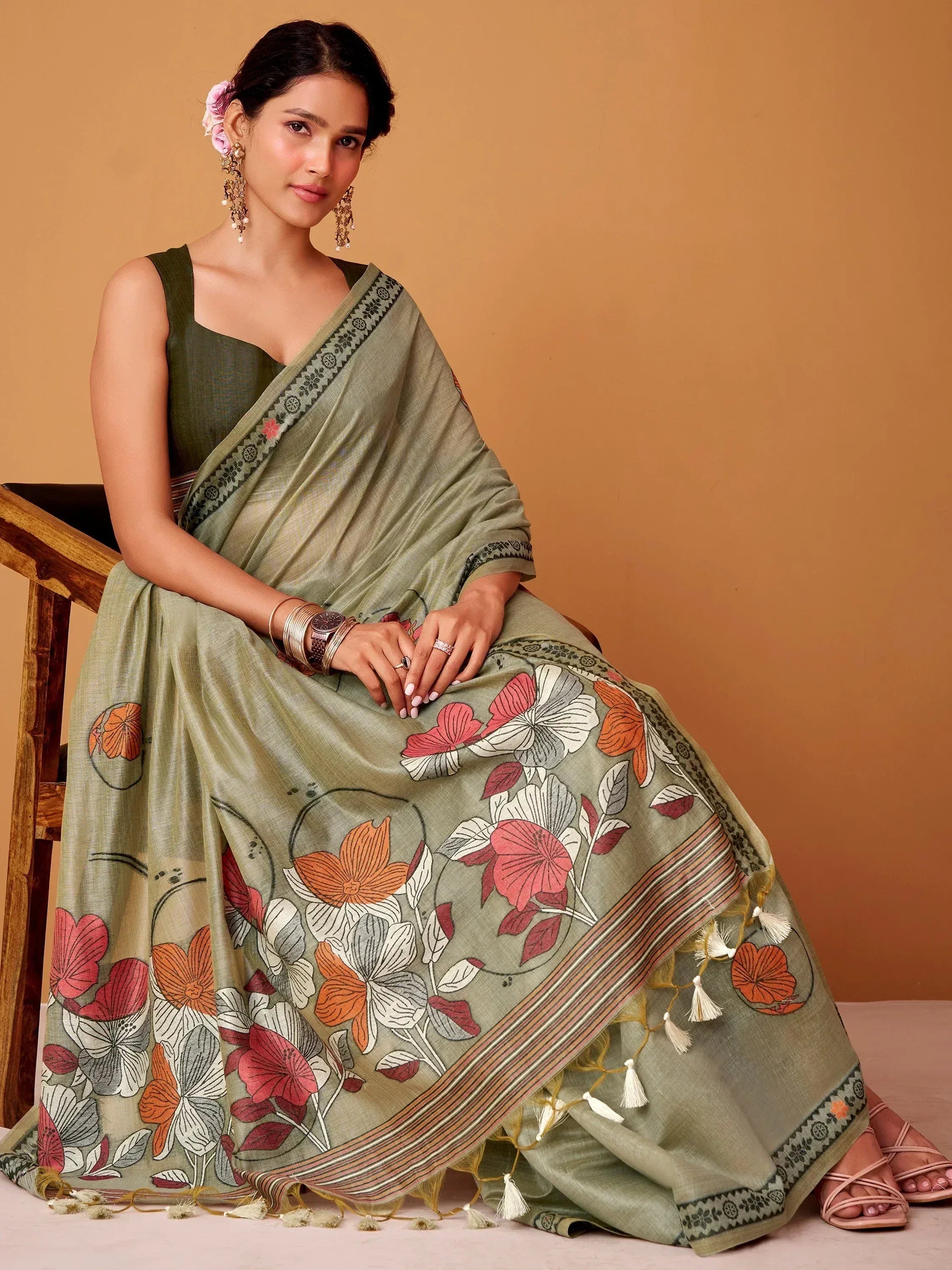 Olive green floral print saree with tassels, paired with matching sleeveless blouse, ideal for ethnic occasions.