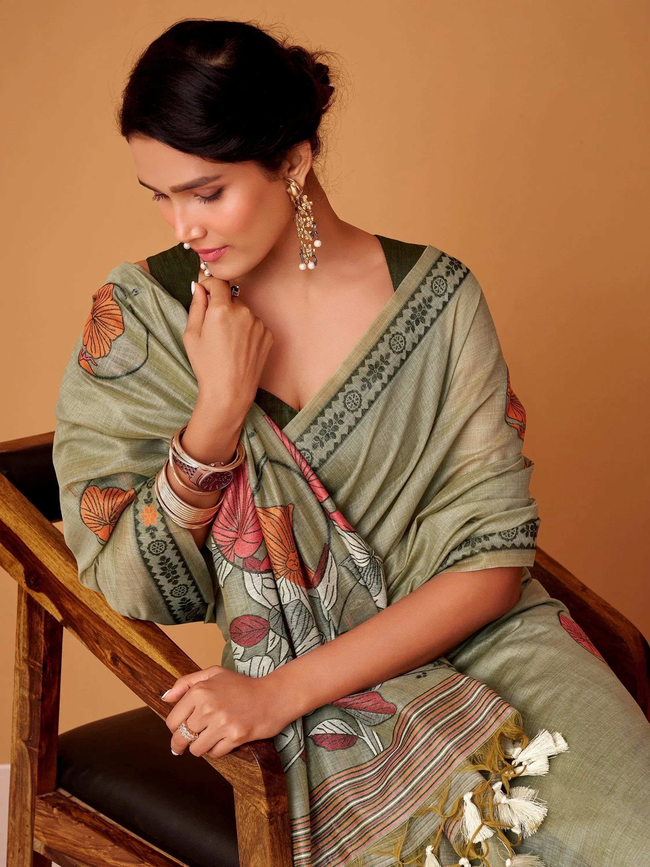 Woman in olive green floral printed saree with tassels, ethnic wear for Indian occasions