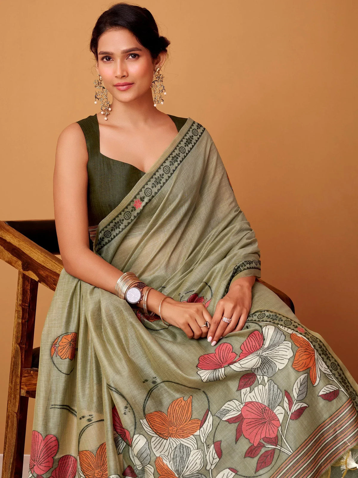 Olive green floral print saree with designer border, paired with sleeveless blouse, perfect for ethnic occasions