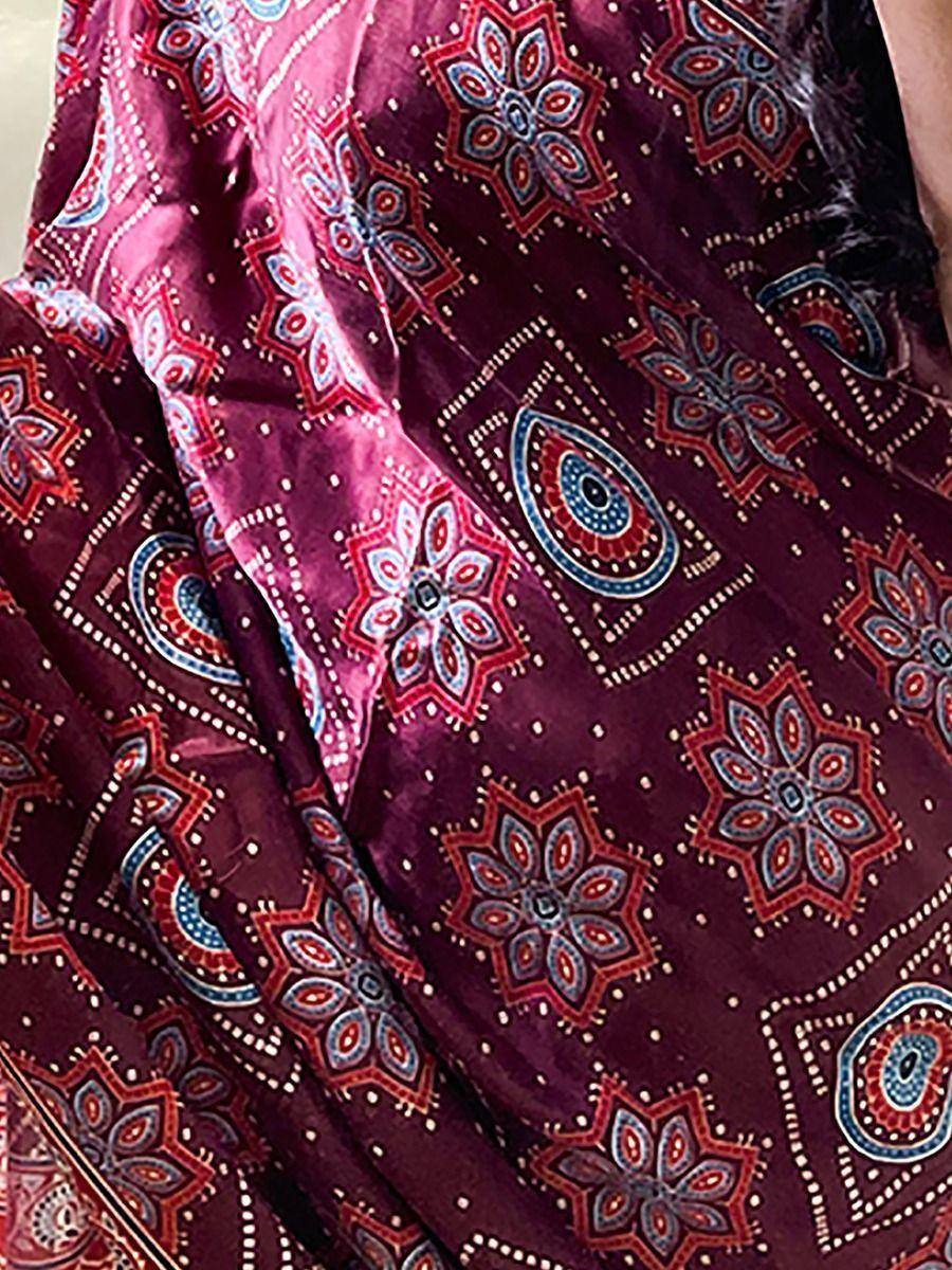 Rich maroon ethnic saree with intricate floral and paisley prints in red, blue, and white.