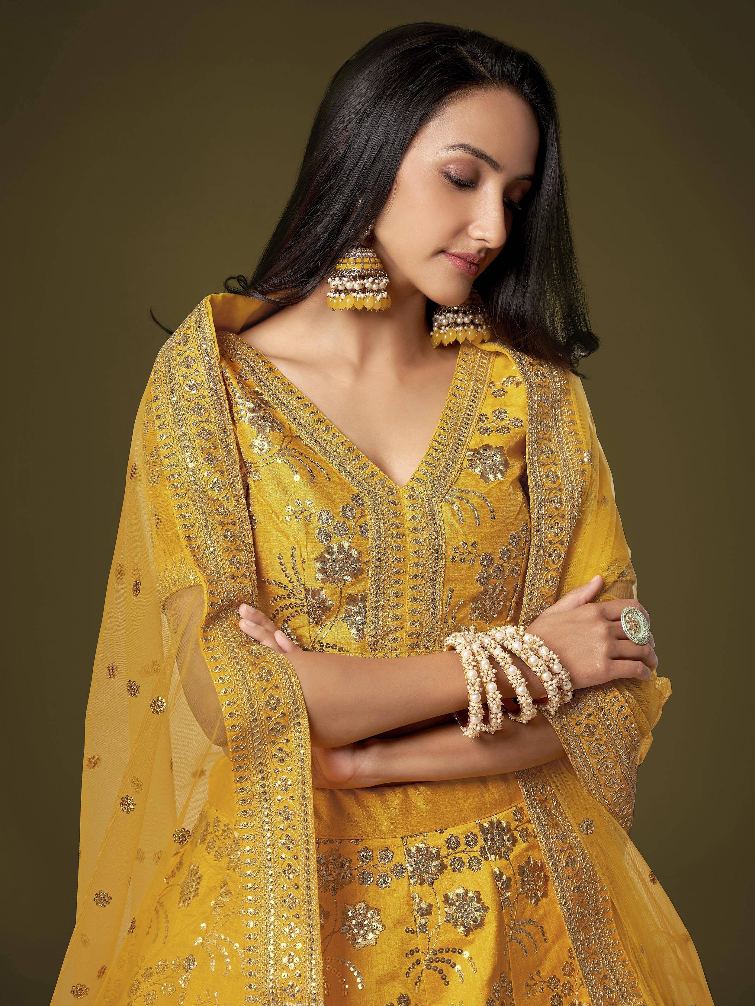 Yellow embroidered ethnic gown with floral motifs and matching jewelry for Indian wear