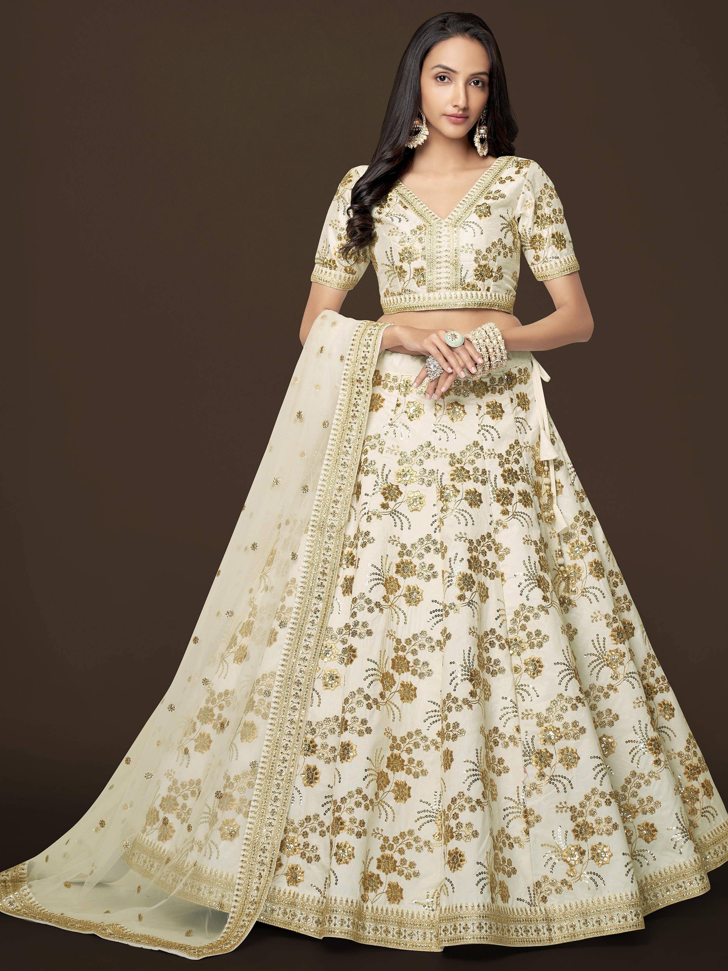 Cream and gold embroidered lehenga choli with floral zari work, perfect for Indian weddings and festive occasions.