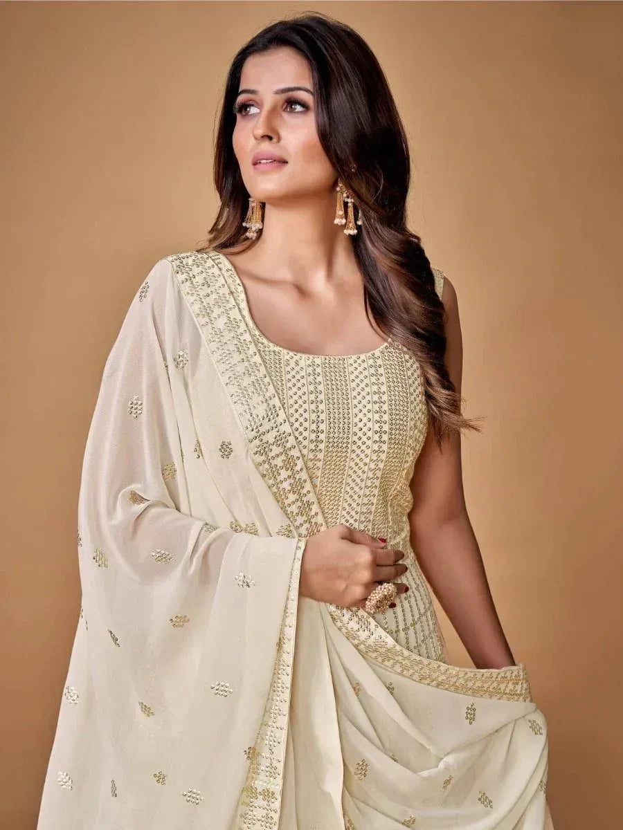 Elegant cream ethnic gown with gold embroidery, perfect for Indian occasions and festive wear.