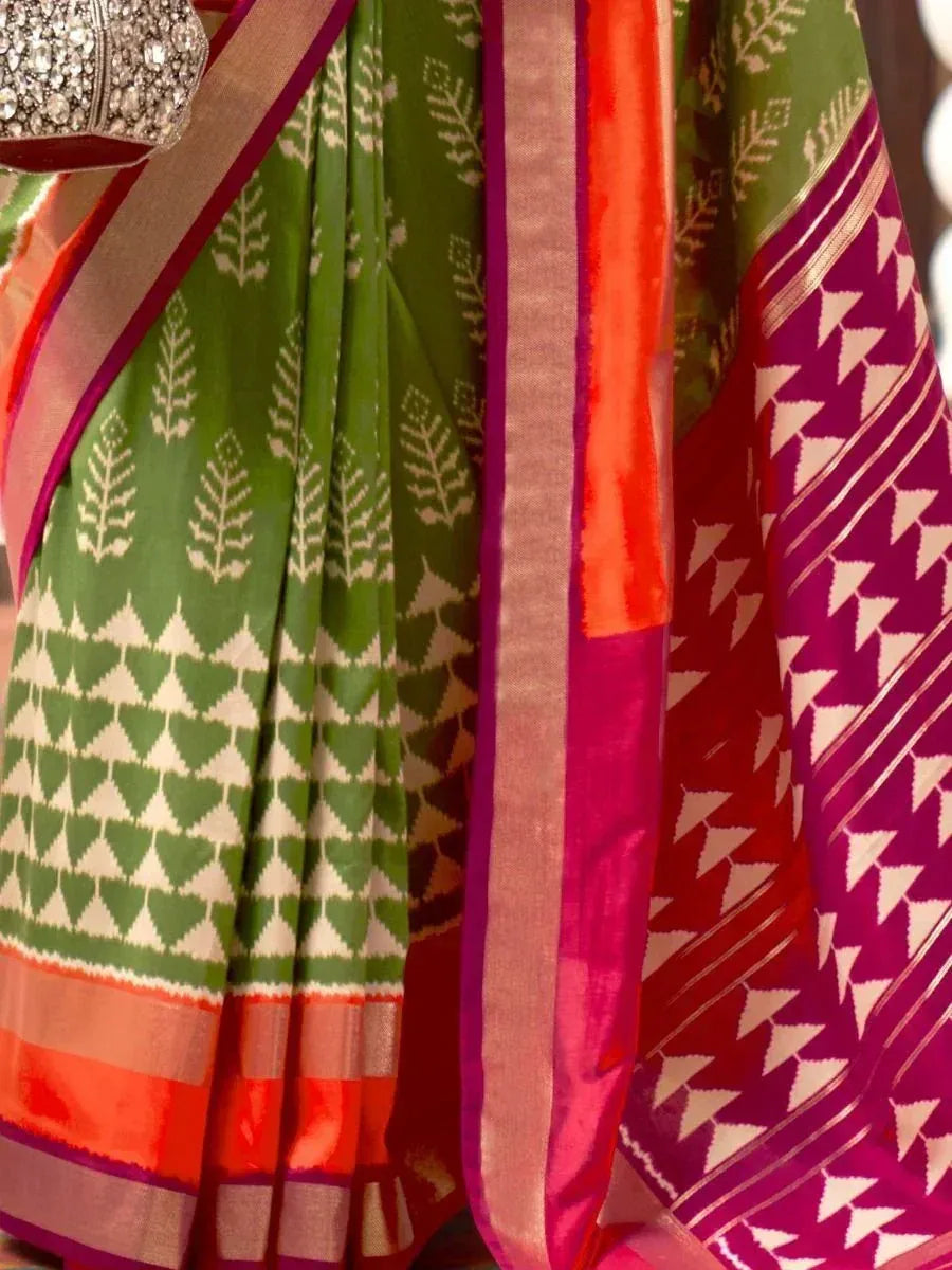 Green and magenta Ikat saree with geometric leaf patterns and vibrant border, ethnic Indian wear