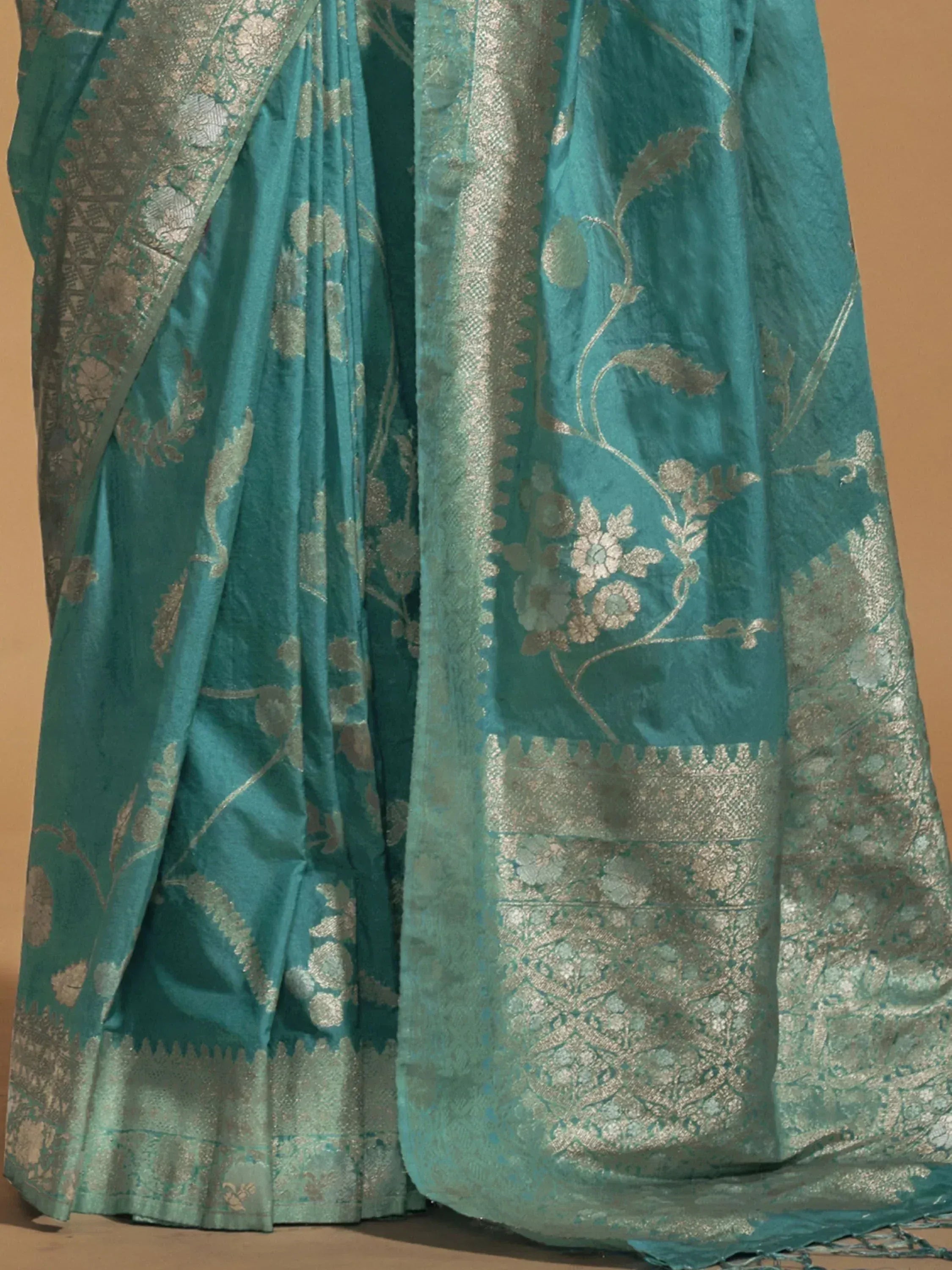 Teal silk saree with silver floral zari work and intricate border, ideal for ethnic occasions