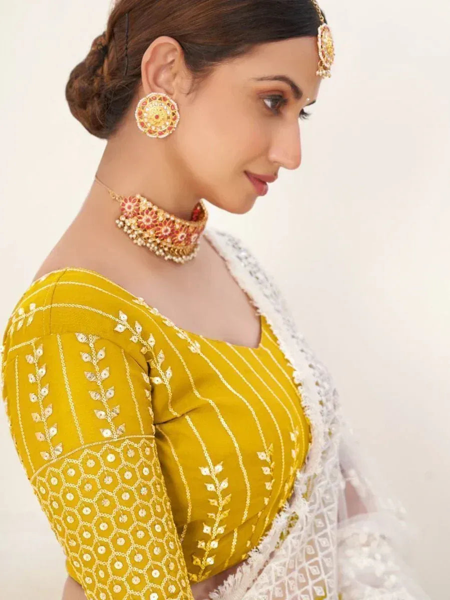 Yellow embroidered blouse with white dupatta, traditional Indian ethnic wear, paired with gold jewelry
