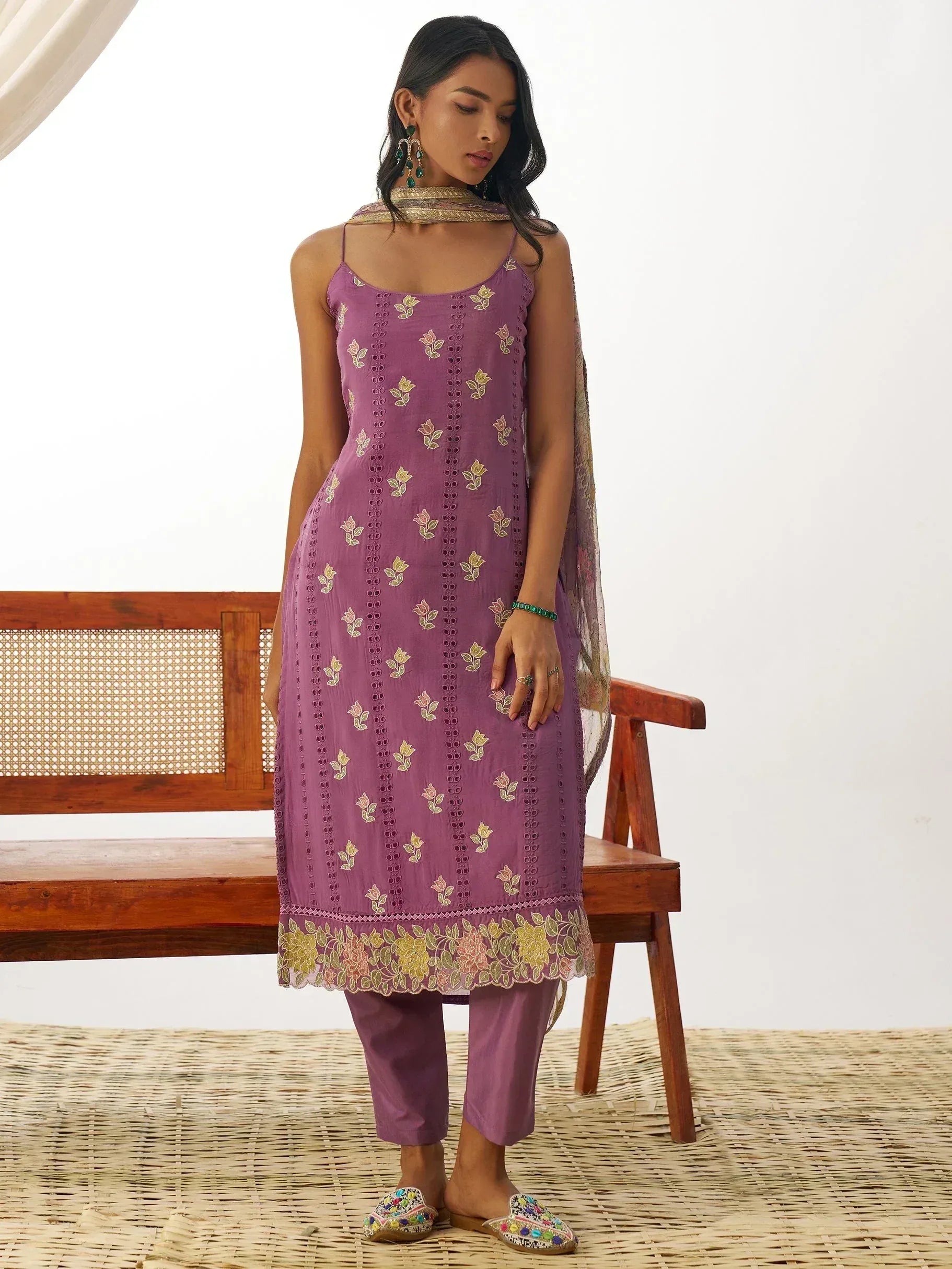 Purple embroidered kurta with floral motifs, matching pants, and dupatta, styled with ethnic jewelry and juttis.