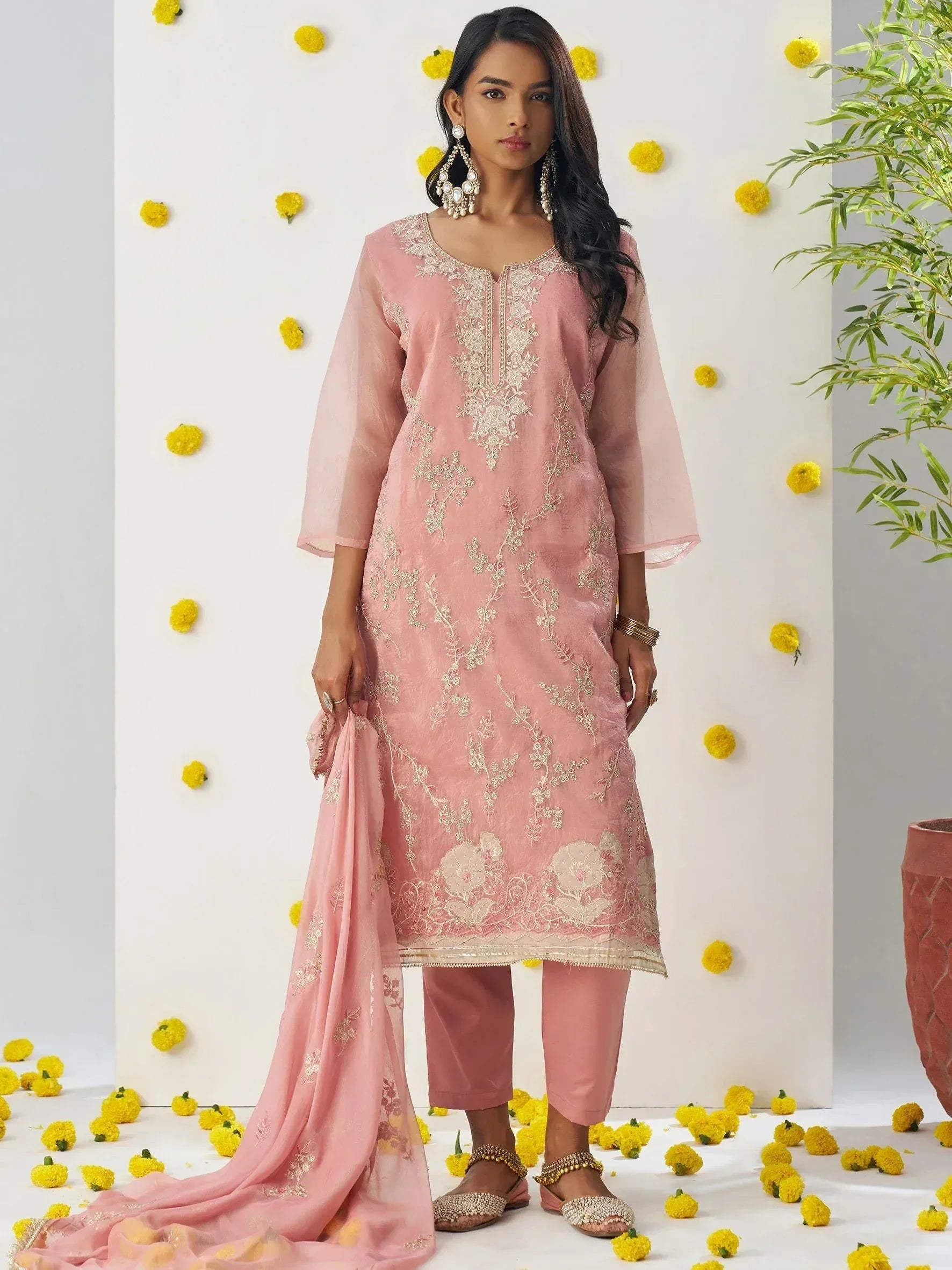 Pink embroidered salwar kameez with floral detailing, matching dupatta, and ethnic jewelry for festive occasions