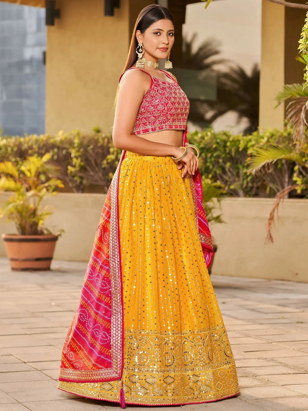 Yellow and pink embroidered lehenga choli with mirror work, perfect for Indian ethnic wear