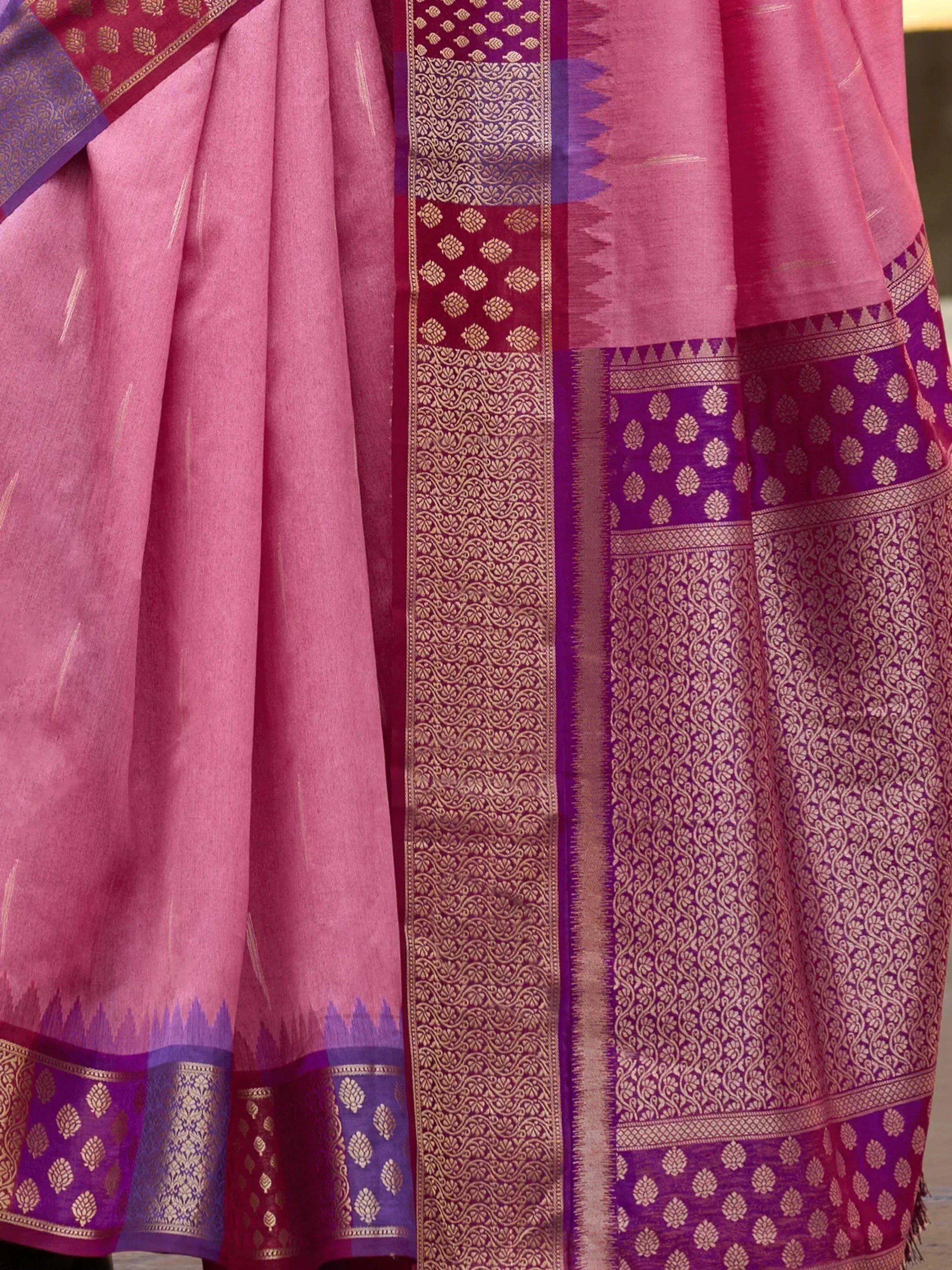 Pink and purple designer saree with intricate gold zari border and traditional Indian ethnic patterns
