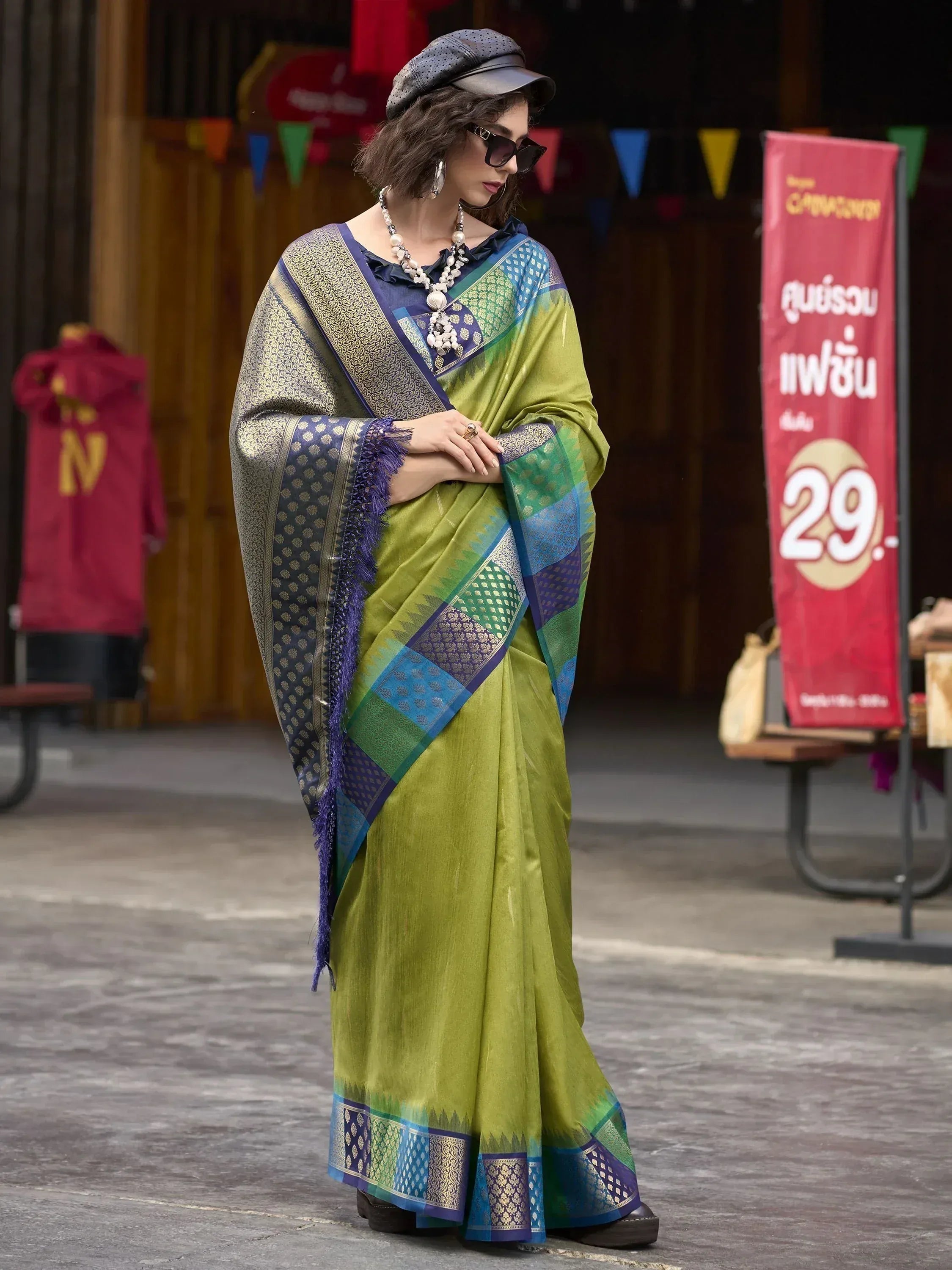 Stylish woman in green and blue designer saree with intricate patterns, perfect for ethnic occasions.