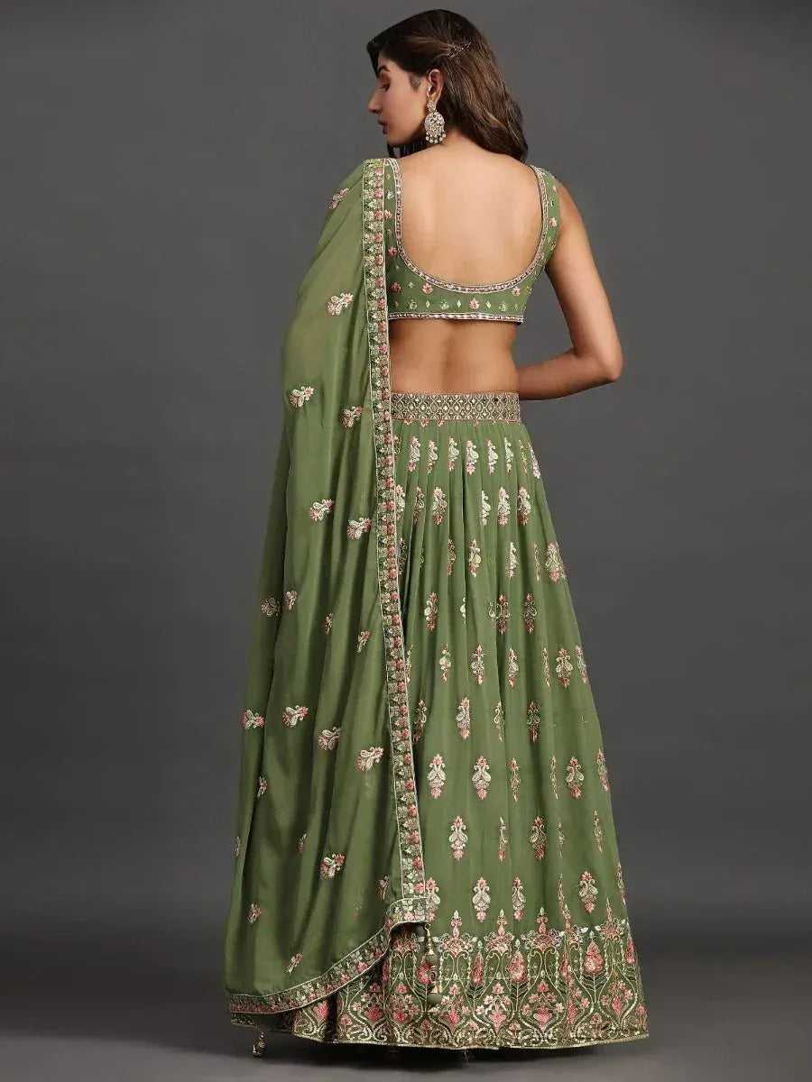 Green embroidered lehenga choli with floral motifs and open back design, perfect for ethnic occasions.