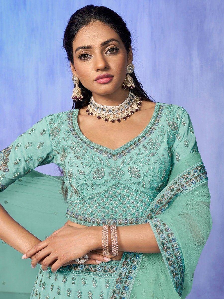 Mint green embroidered lehenga choli with floral motifs and statement jewelry for Indian ethnic wear