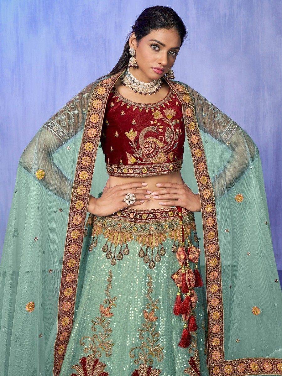 Elegant maroon and mint green lehenga choli with peacock embroidery and tassel detailing for Indian ethnic wear