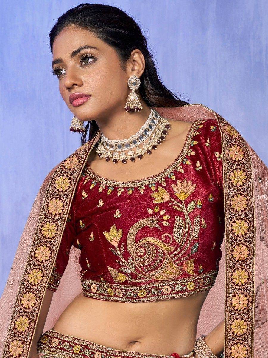 Maroon embroidered lehenga choli with peacock design, floral border, and matching jewelry for Indian ethnic wear