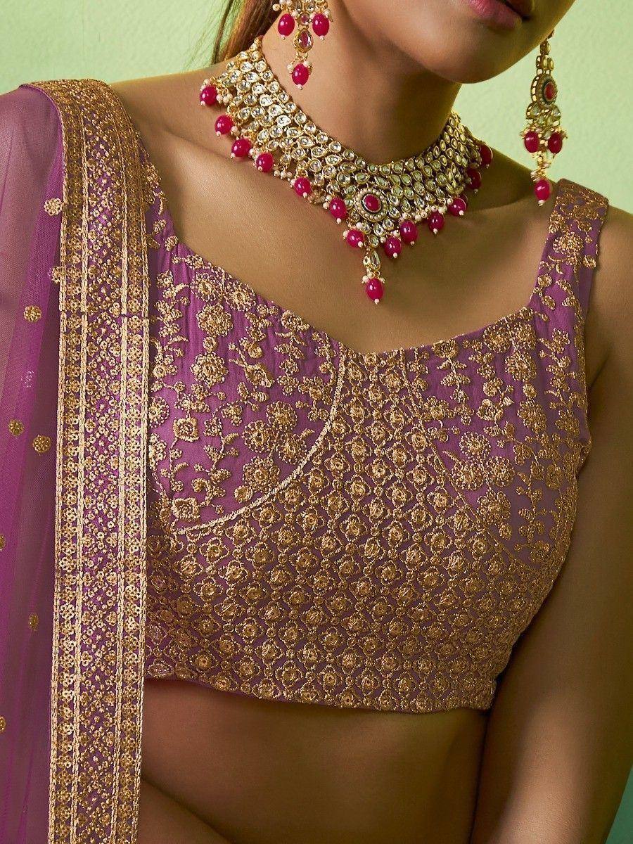 Purple and gold embroidered lehenga choli with matching jewelry, perfect for Indian ethnic wear occasions.