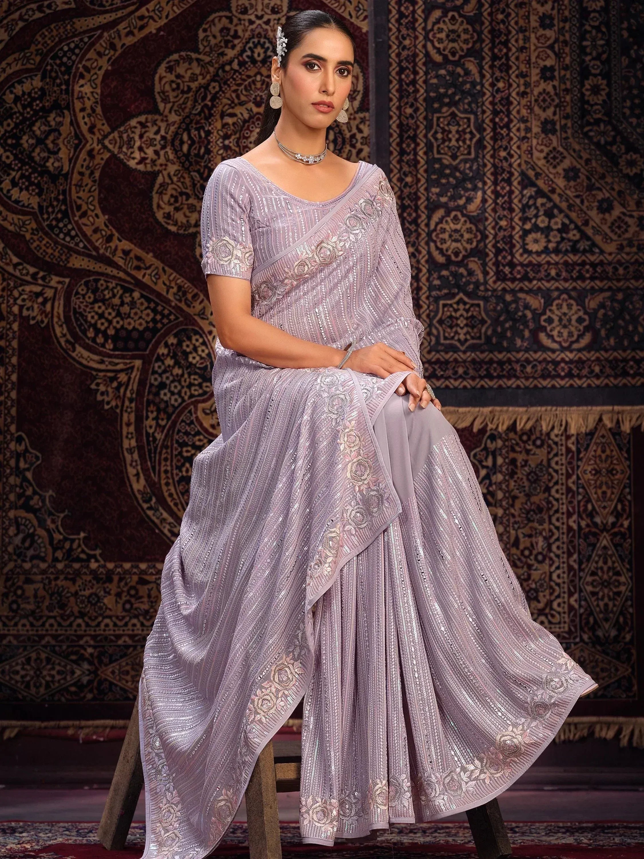 Lavender sequin saree with floral embroidery, styled with matching blouse and ethnic jewelry for festive occasions