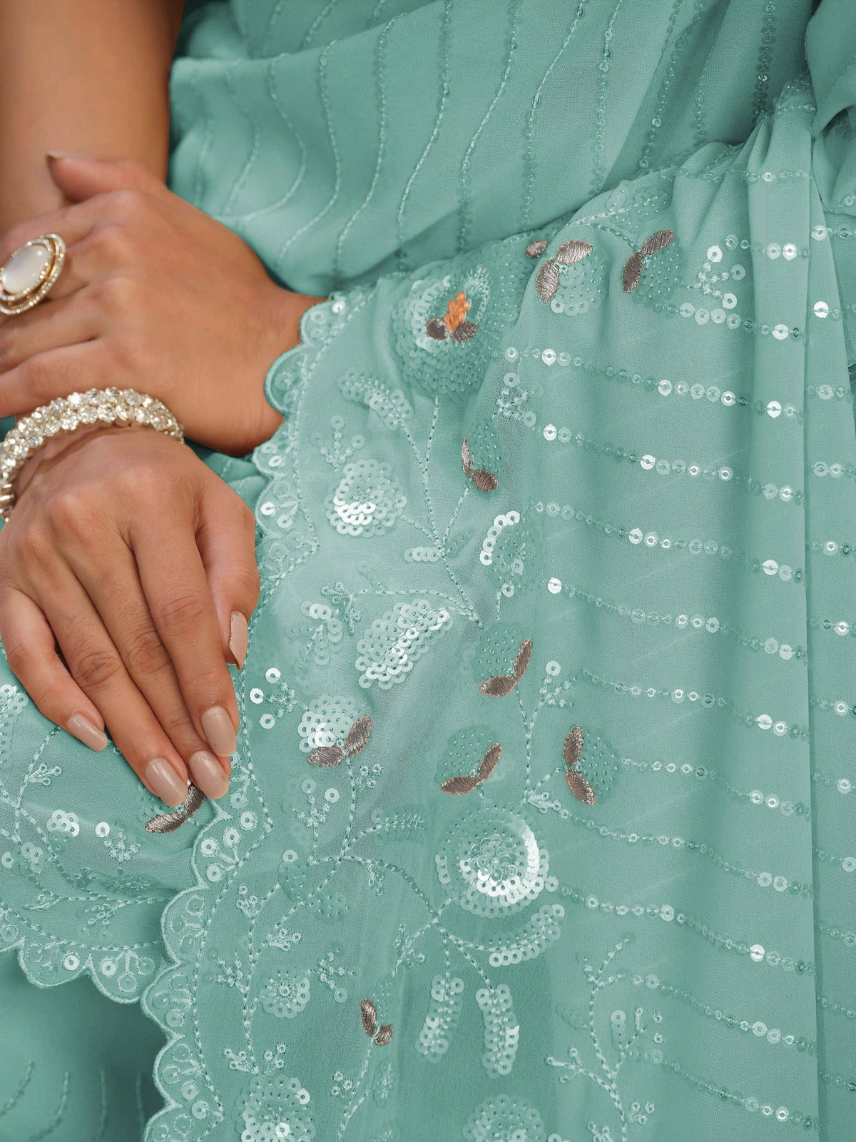 Mint green ethnic gown with sequin floral embroidery and scalloped hem, paired with statement ring and bracelet