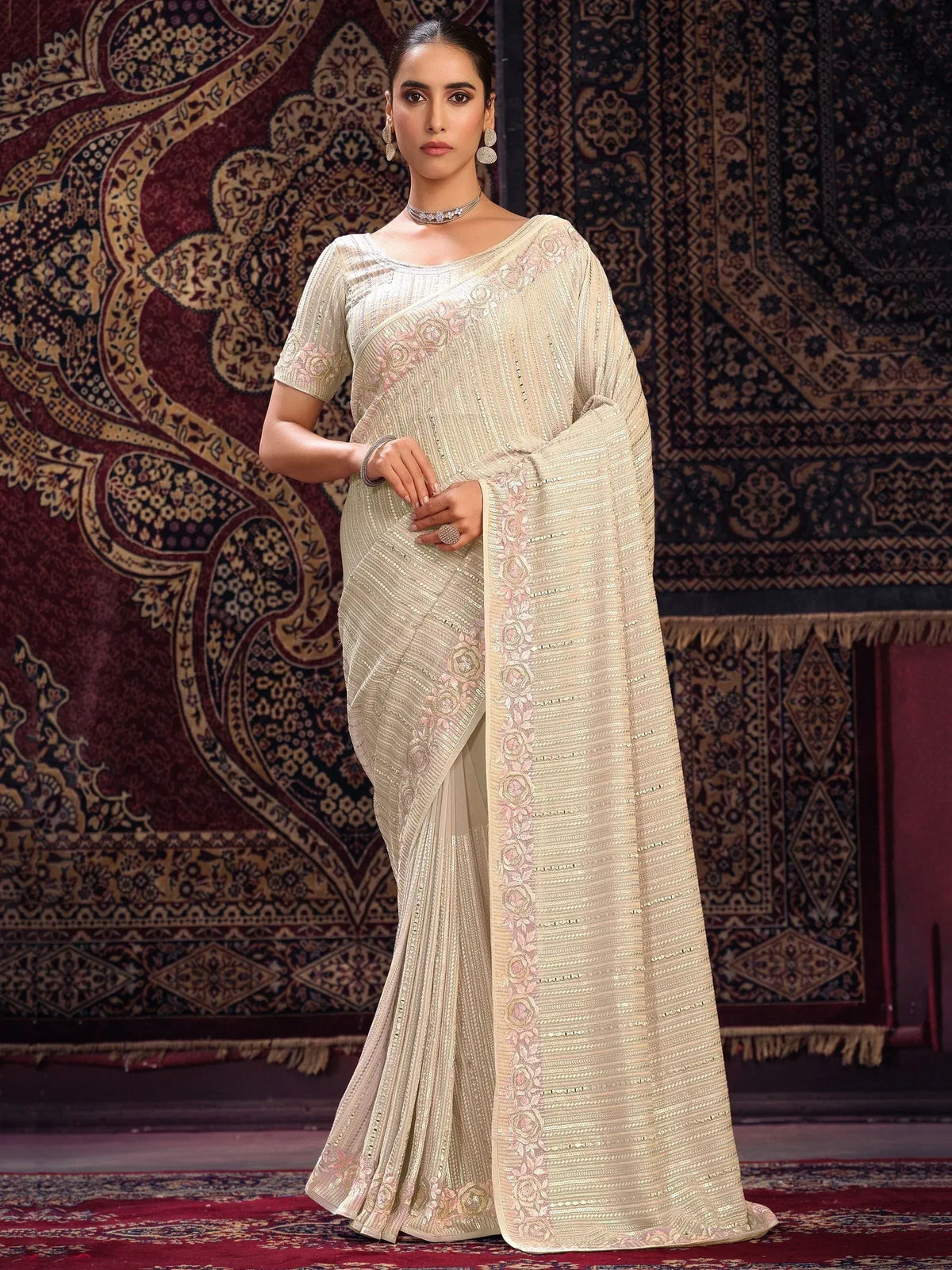 Elegant cream saree with pink floral embroidery and sequin detailing, perfect for Indian ethnic occasions.