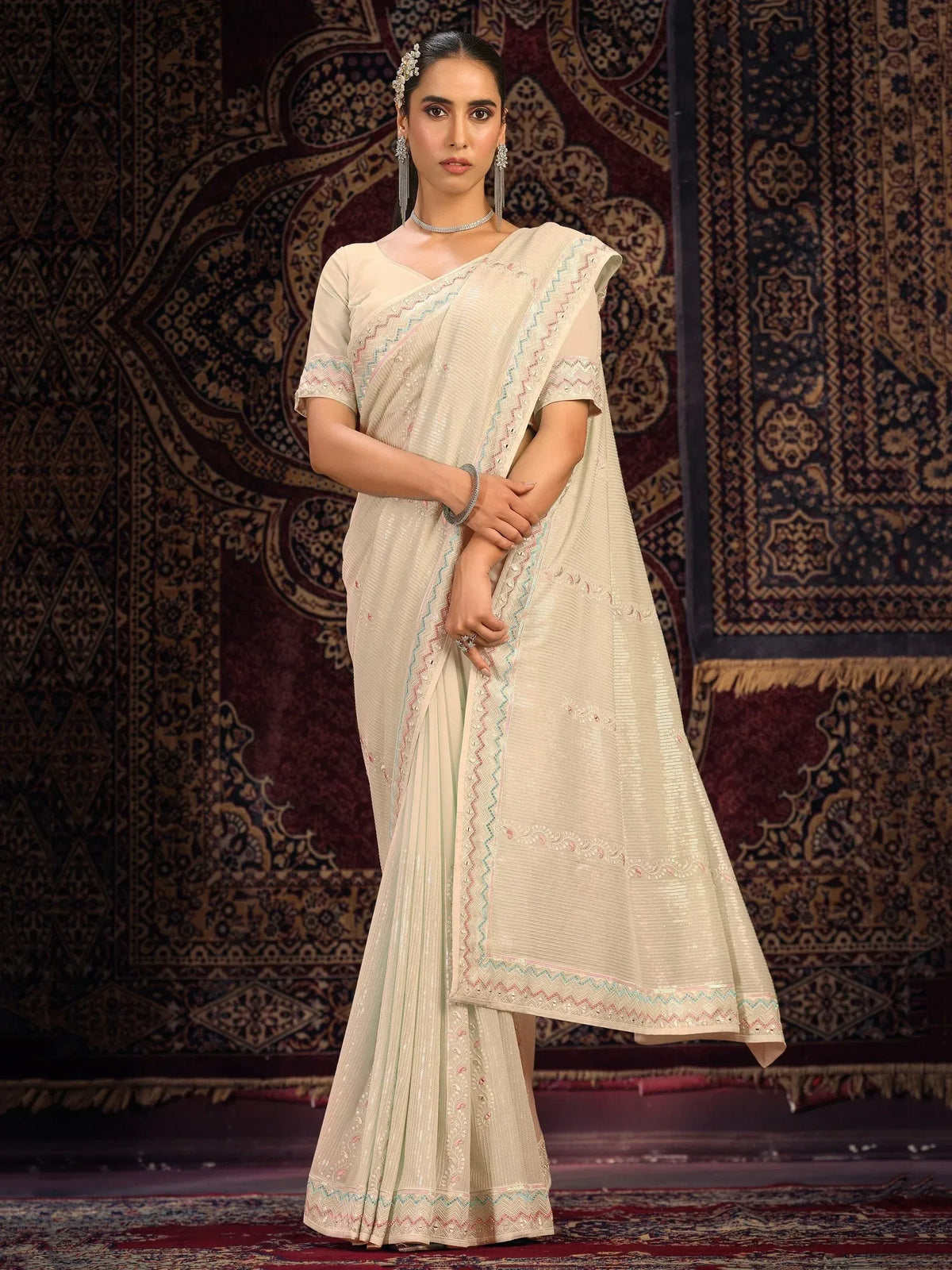 Cream embroidered saree with pastel border, styled with matching blouse and jewelry for ethnic occasions