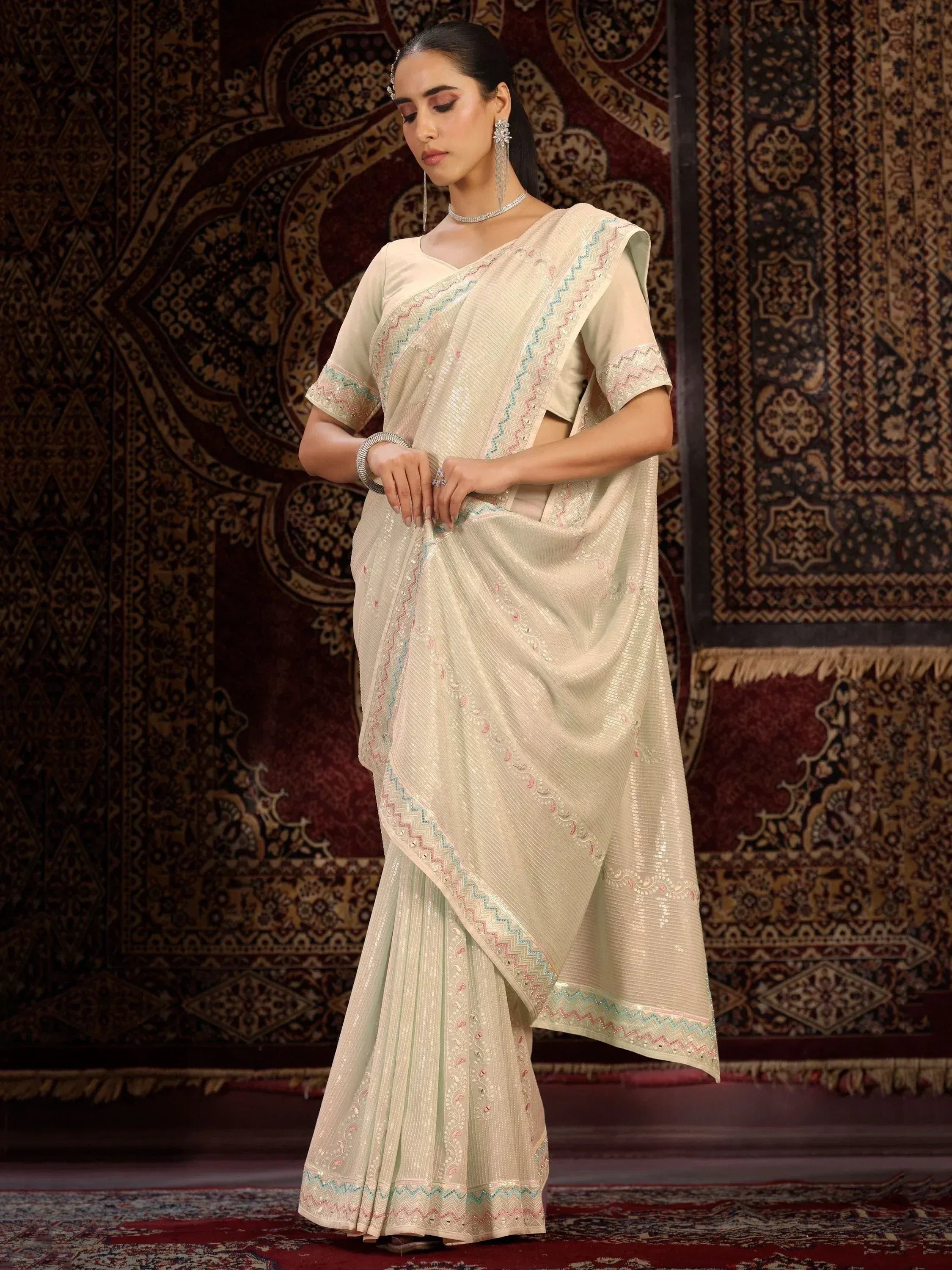 Elegant cream saree with colorful zigzag embroidery, perfect for Indian ethnic wear occasions.