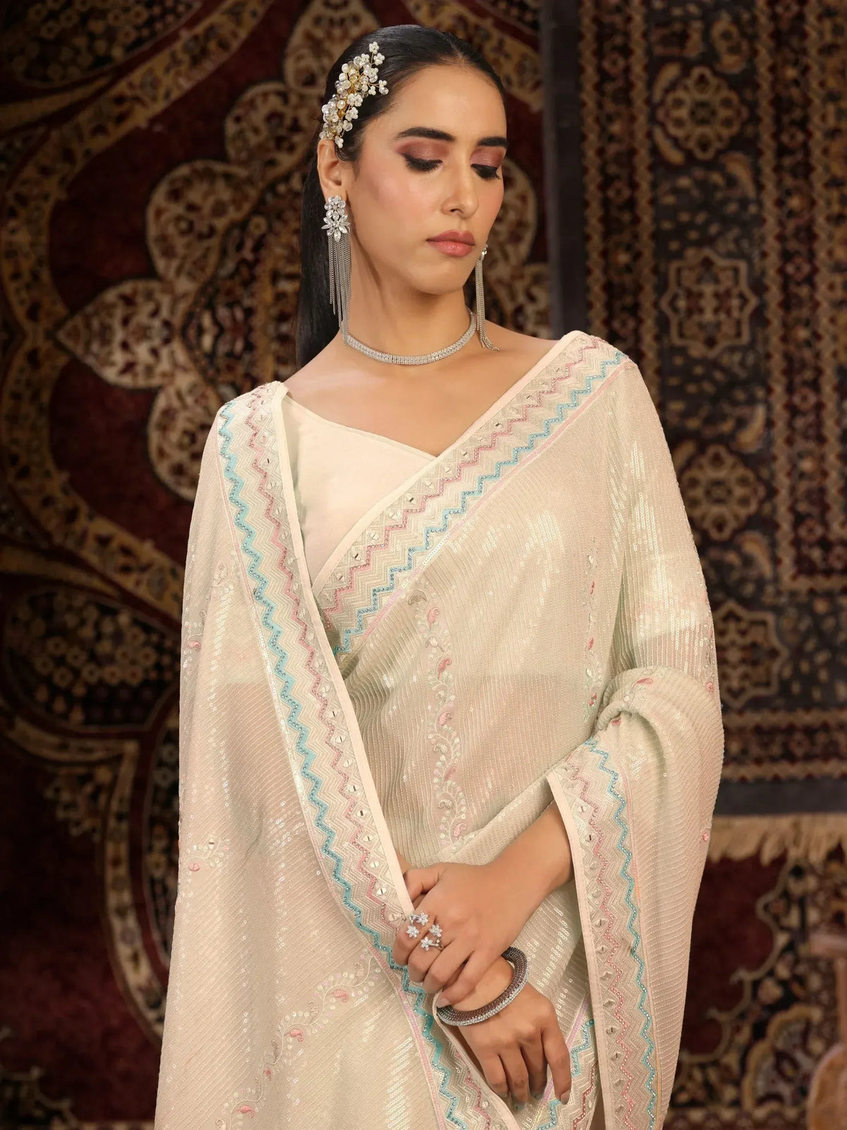 Elegant ivory saree with pastel zigzag border, sequin work, and matching jewelry for Indian ethnic wear