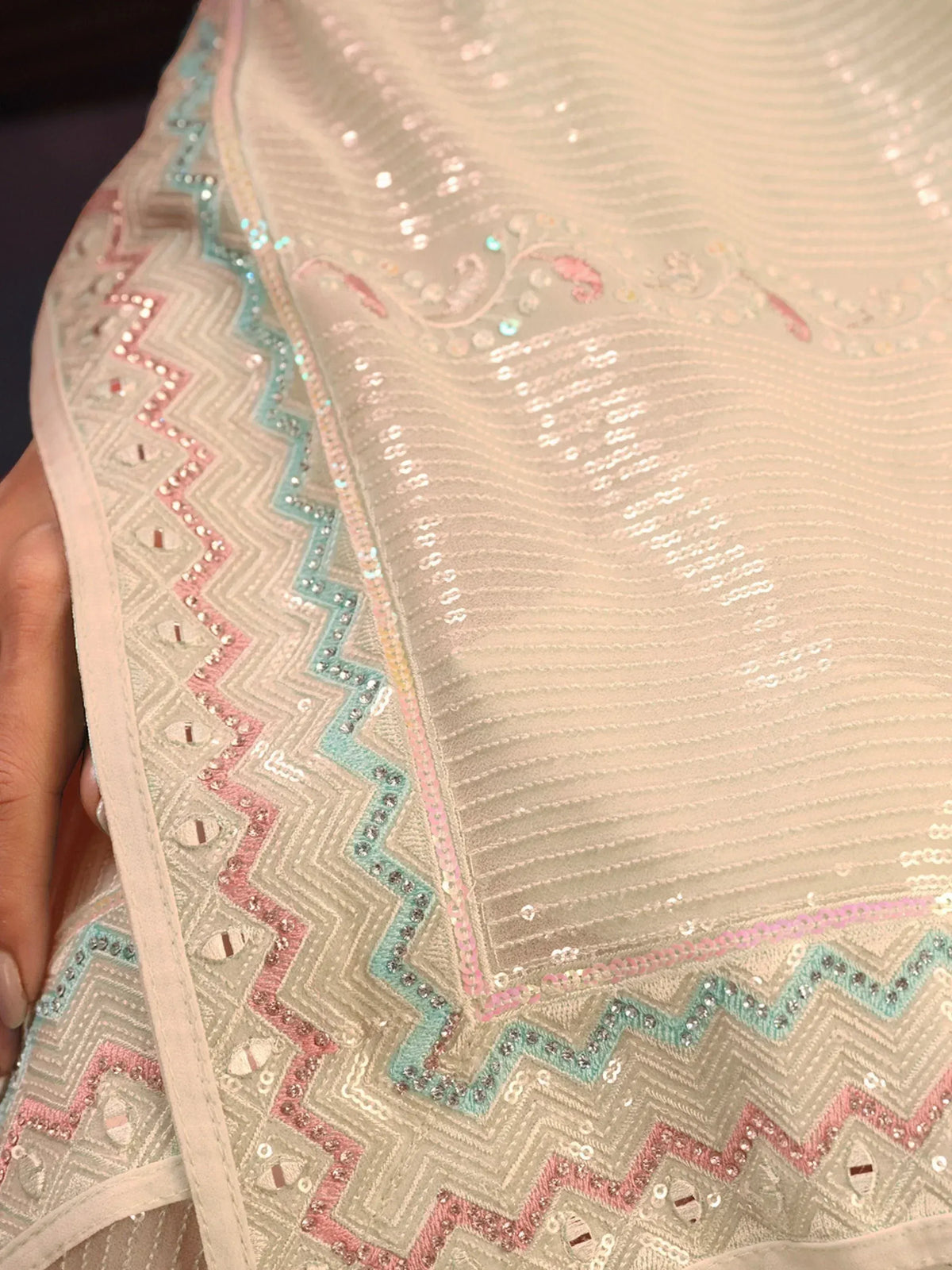 Elegant ethnic wear with intricate sequin embroidery and pastel zigzag border design