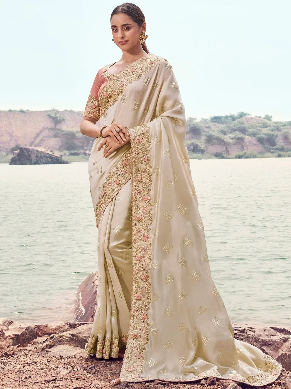 Beige designer saree with gold embroidery and pink floral details, perfect for Indian ethnic occasions