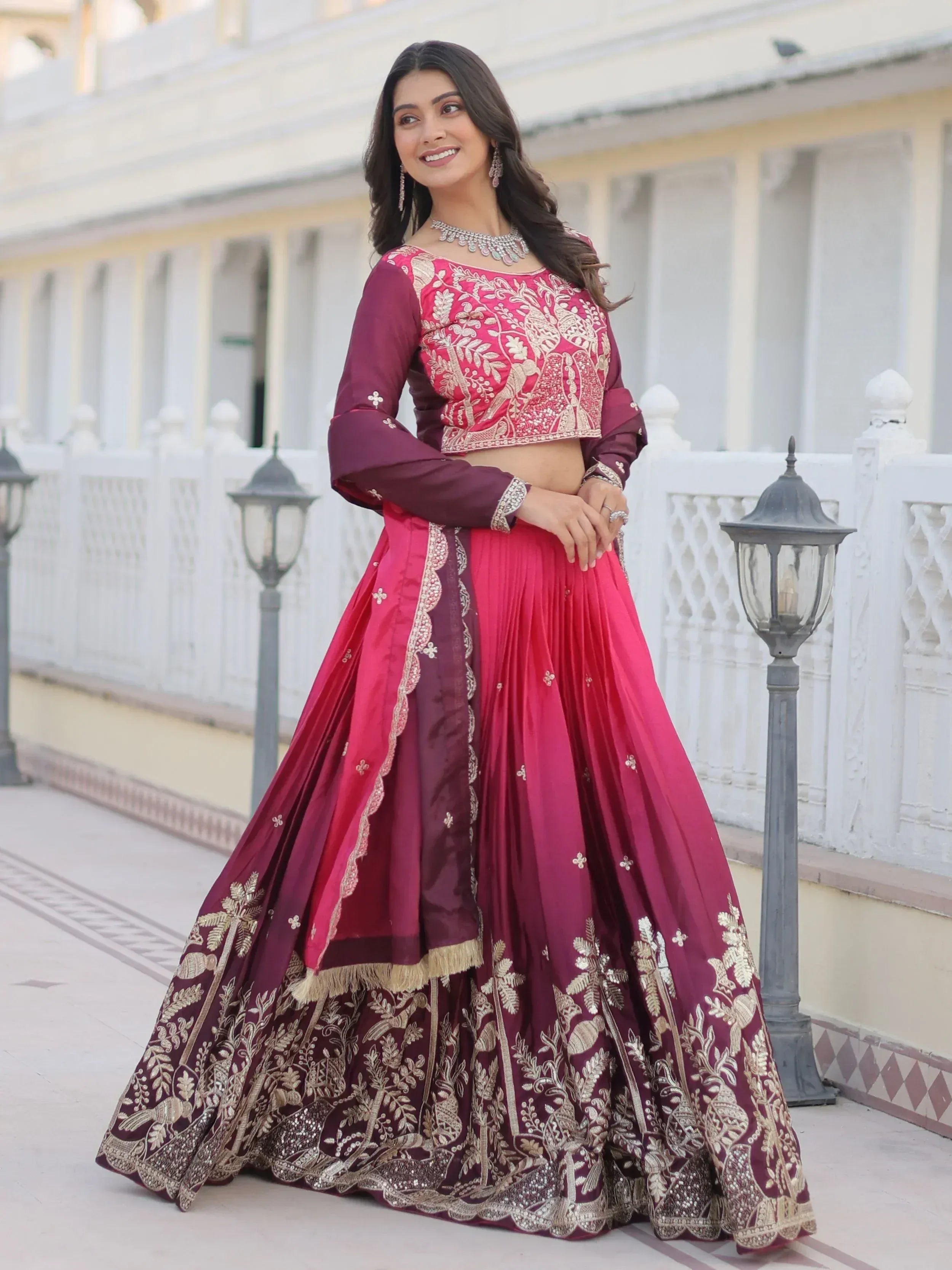Elegant maroon and pink embroidered lehenga choli with gold detailing, perfect for Indian weddings and festive occasions.